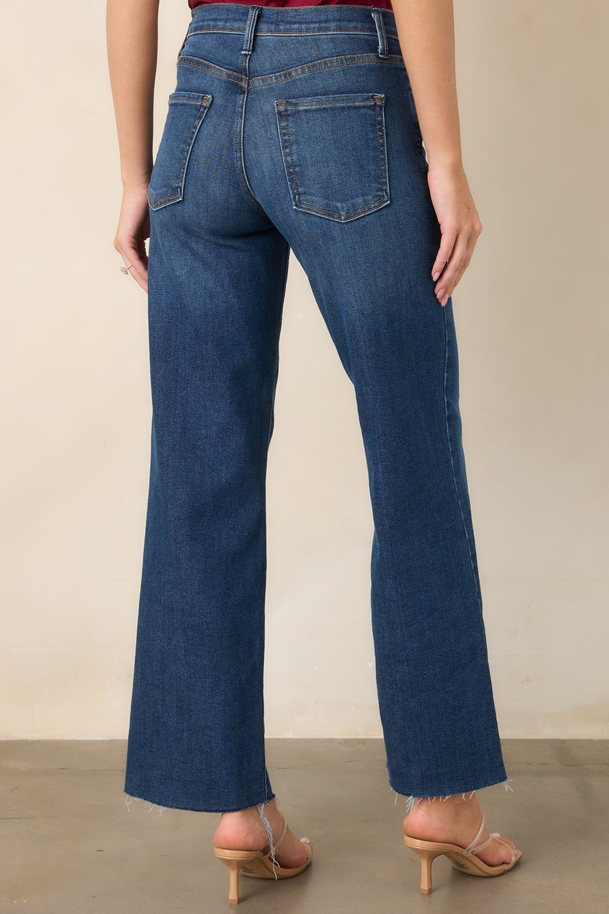 Rear view of the dark wash jeans showcasing functional back pockets, belt loops, high-rise waistband, and straight-leg cut.