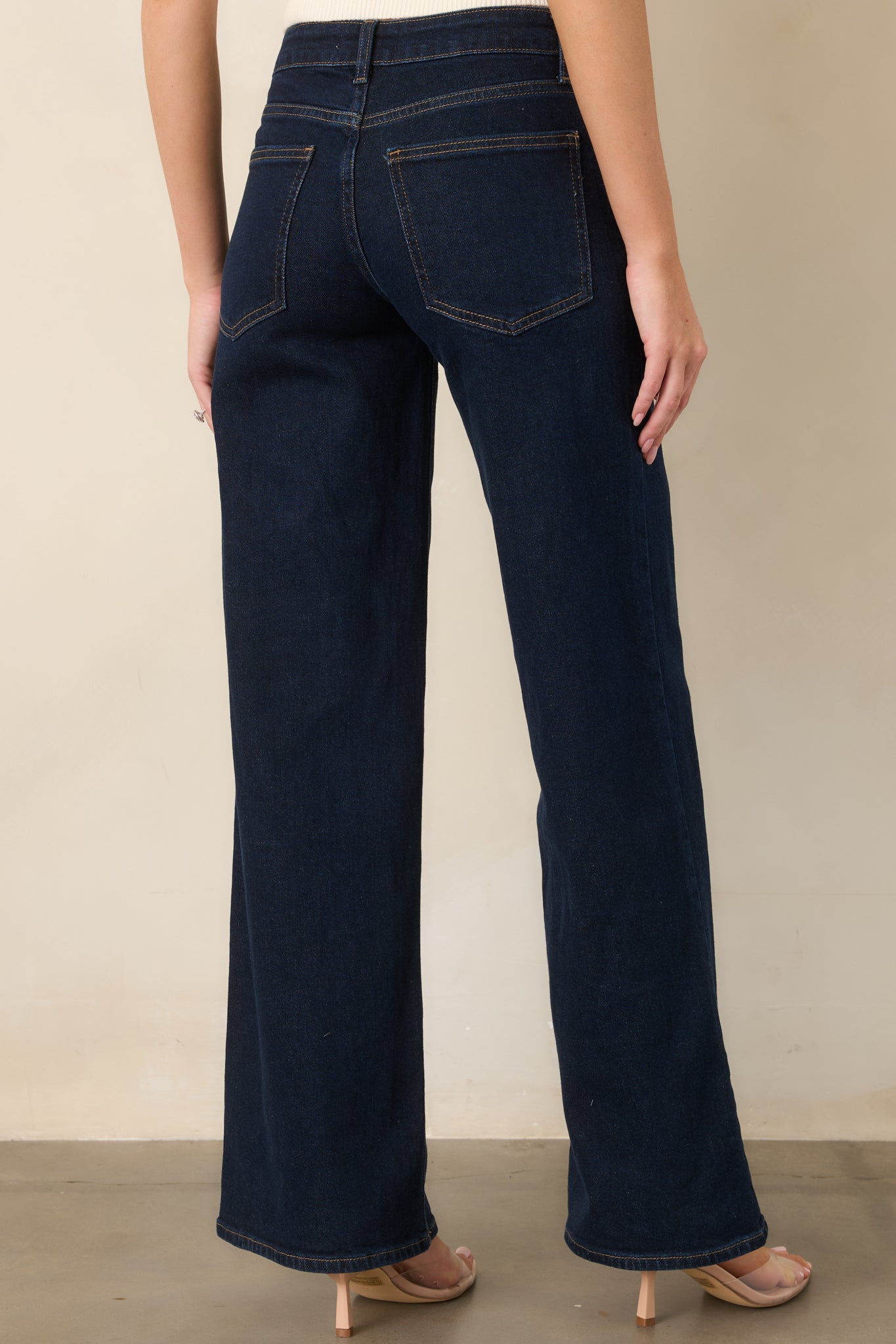 Rear view of the dark wash jeans showcasing classic back pockets, high-rise construction, and full-length wide legs.