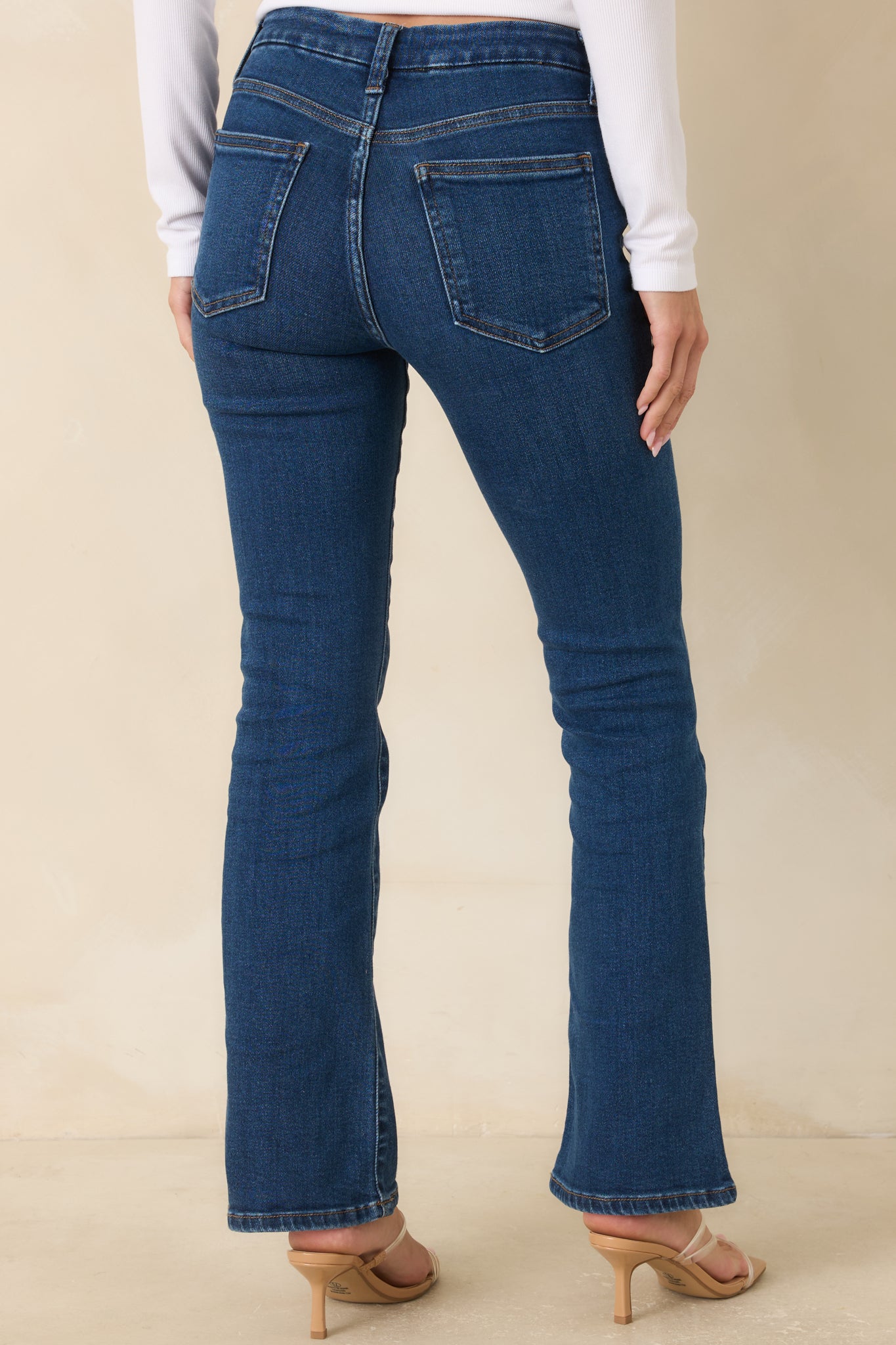 Back view of dark wash straight leg jeans featuring classic back pockets and subtle fading.