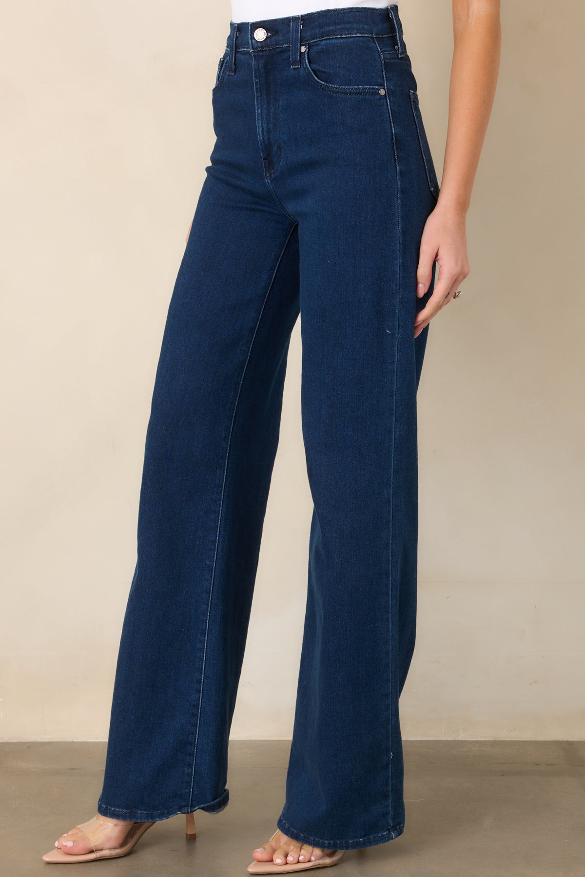 Dark wash jeans showcasing the classic waistband and wide-leg construction.
