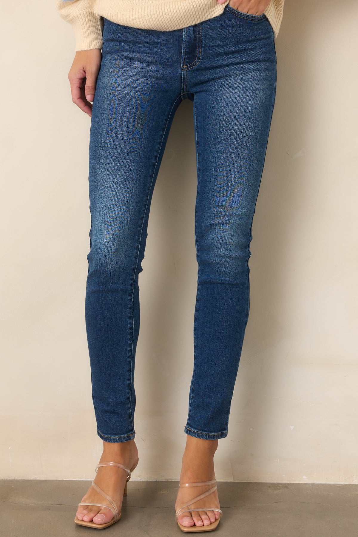 Dark wash jeans highlighting the high-rise waistband and slim stretch fit.