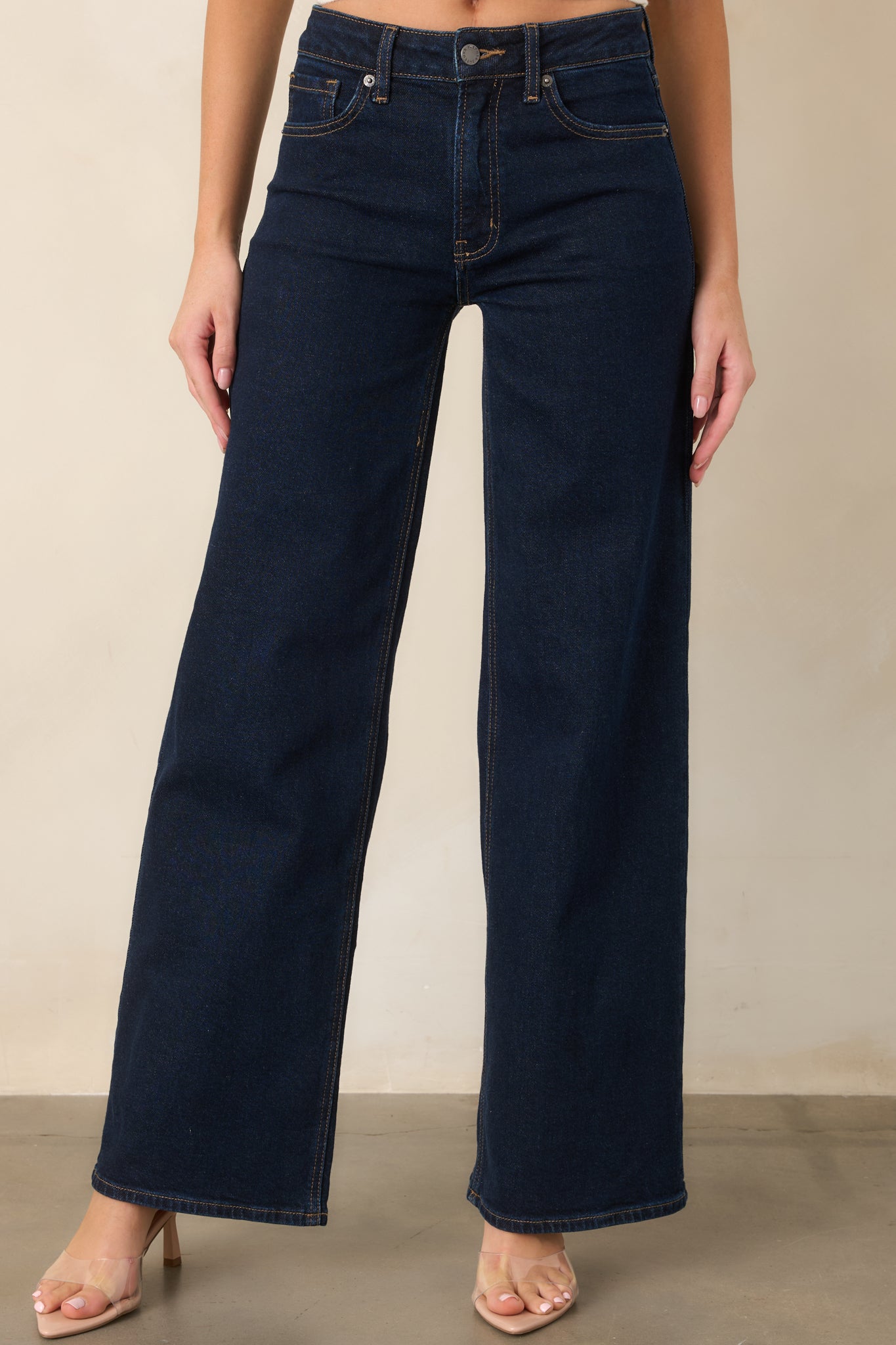 Close view of the dark wash jeans highlighting the high-rise waistband and structured stretch denim.