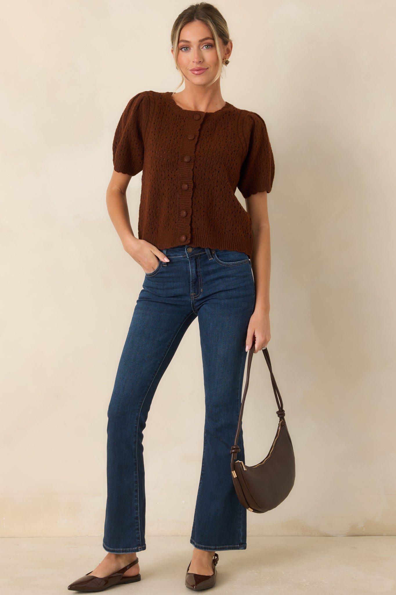 Dark wash mid-rise flare jeans with contrast stitching, a classic button-and-zip closure, and a fitted silhouette that gradually flares below the knee.