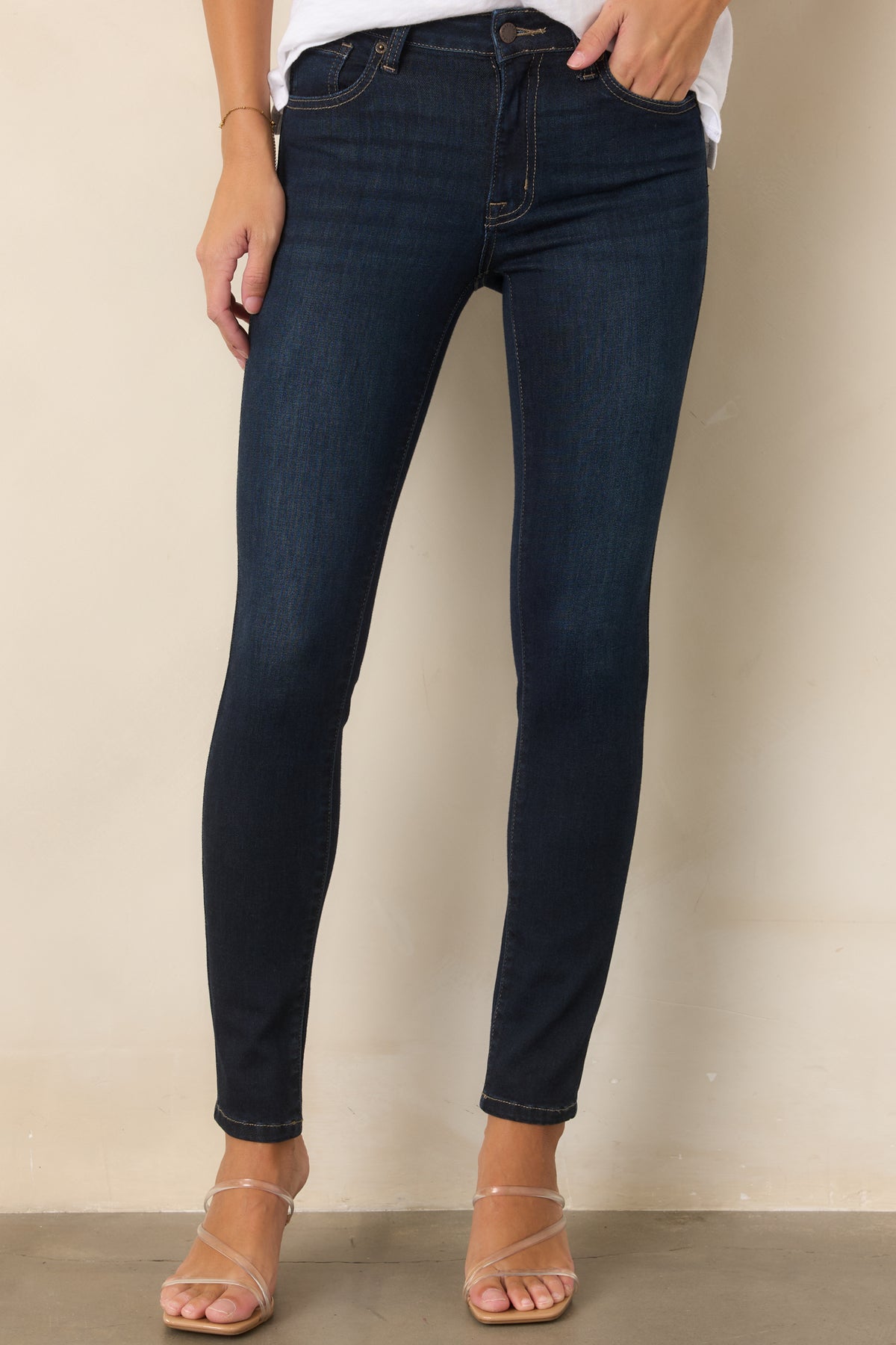 Dark wash skinny jeans highlighting the smooth waistband and fitted upper silhouette.