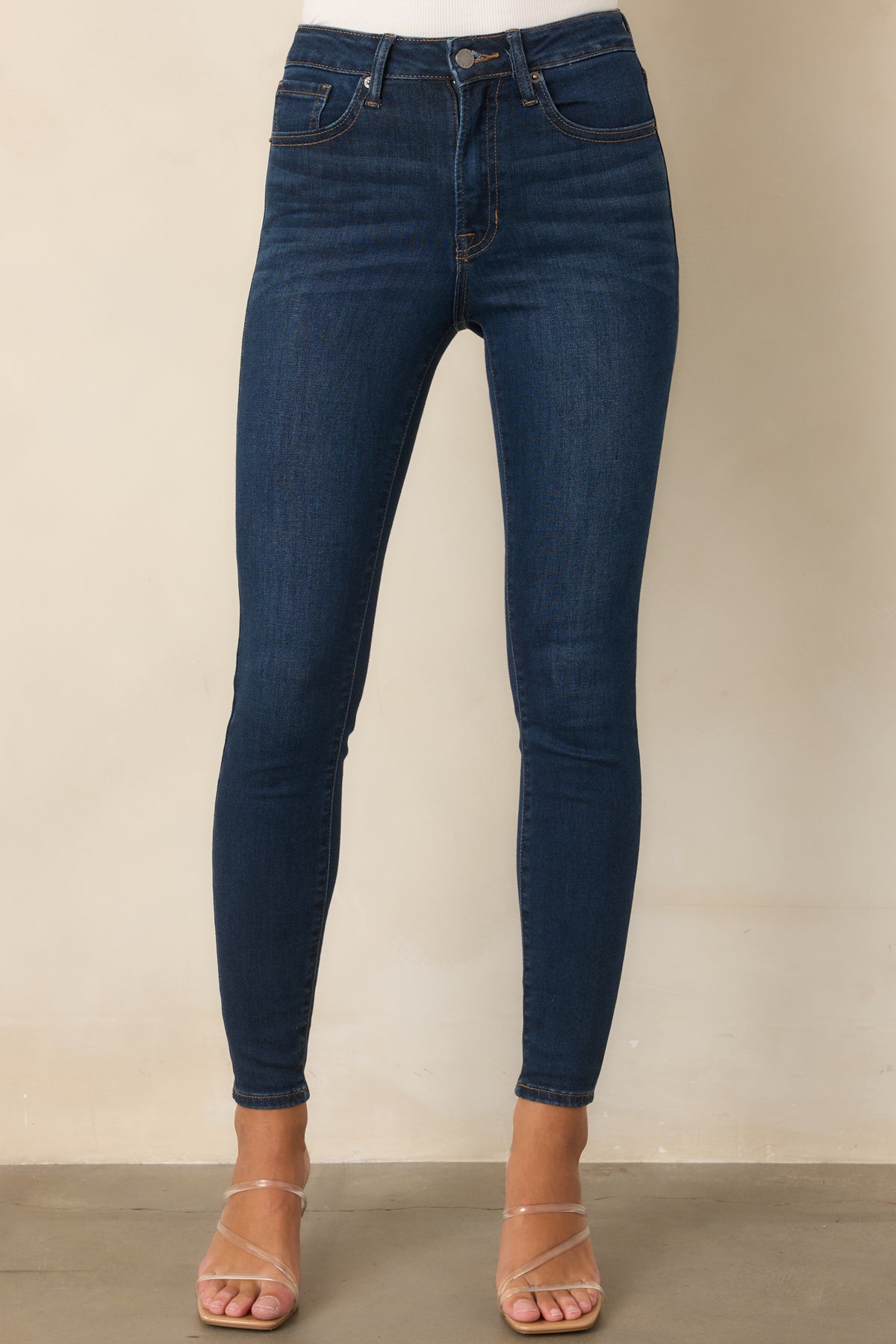 Dark wash skinny pants highlighting the close fit, smooth stretch construction, and classic five-pocket styling.