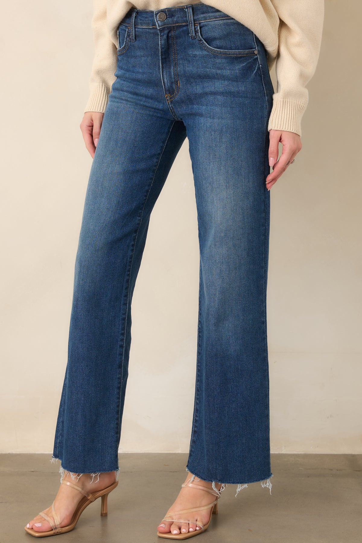 Dark wash denim showcasing the straight-leg cut, high waistband, and clean five-pocket design.