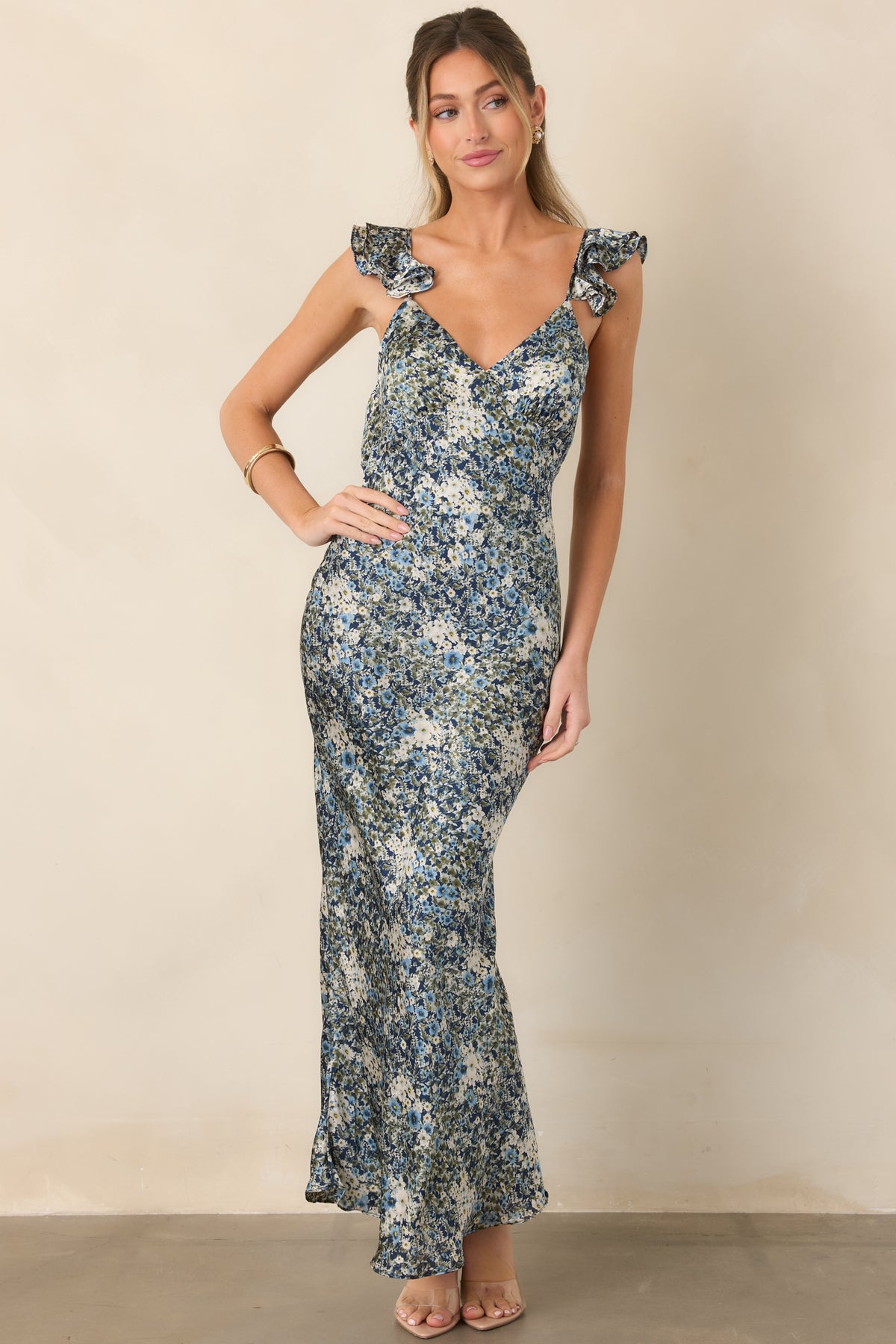 Sleek satin dress featuring an allover deep blue floral print and romantic ruffled straps.