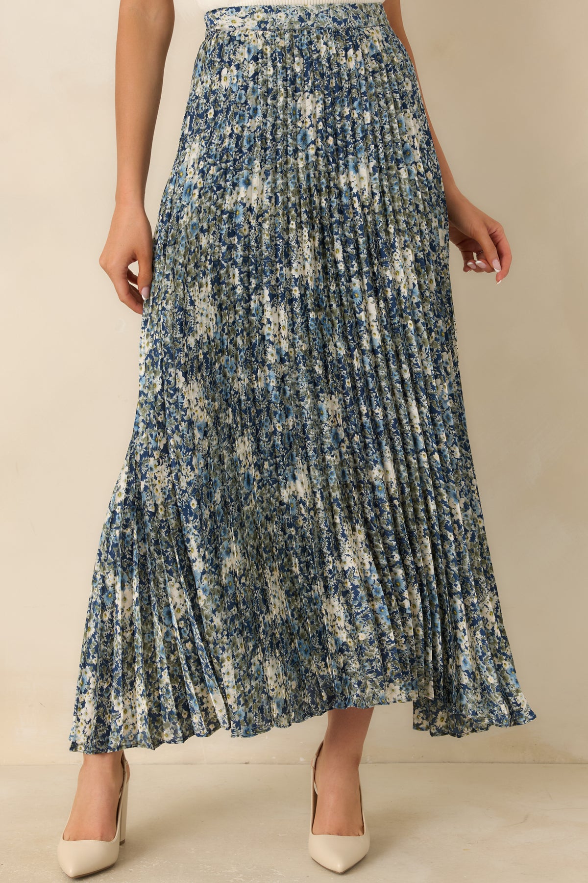 Flowing pleated skirt with a deep blue base and an allover pattern of muted floral accents.