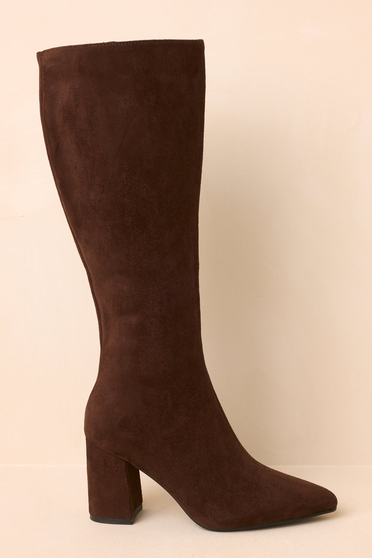 Deep brown boots showcasing the sleek pointed toe and fitted knee-high shaft.