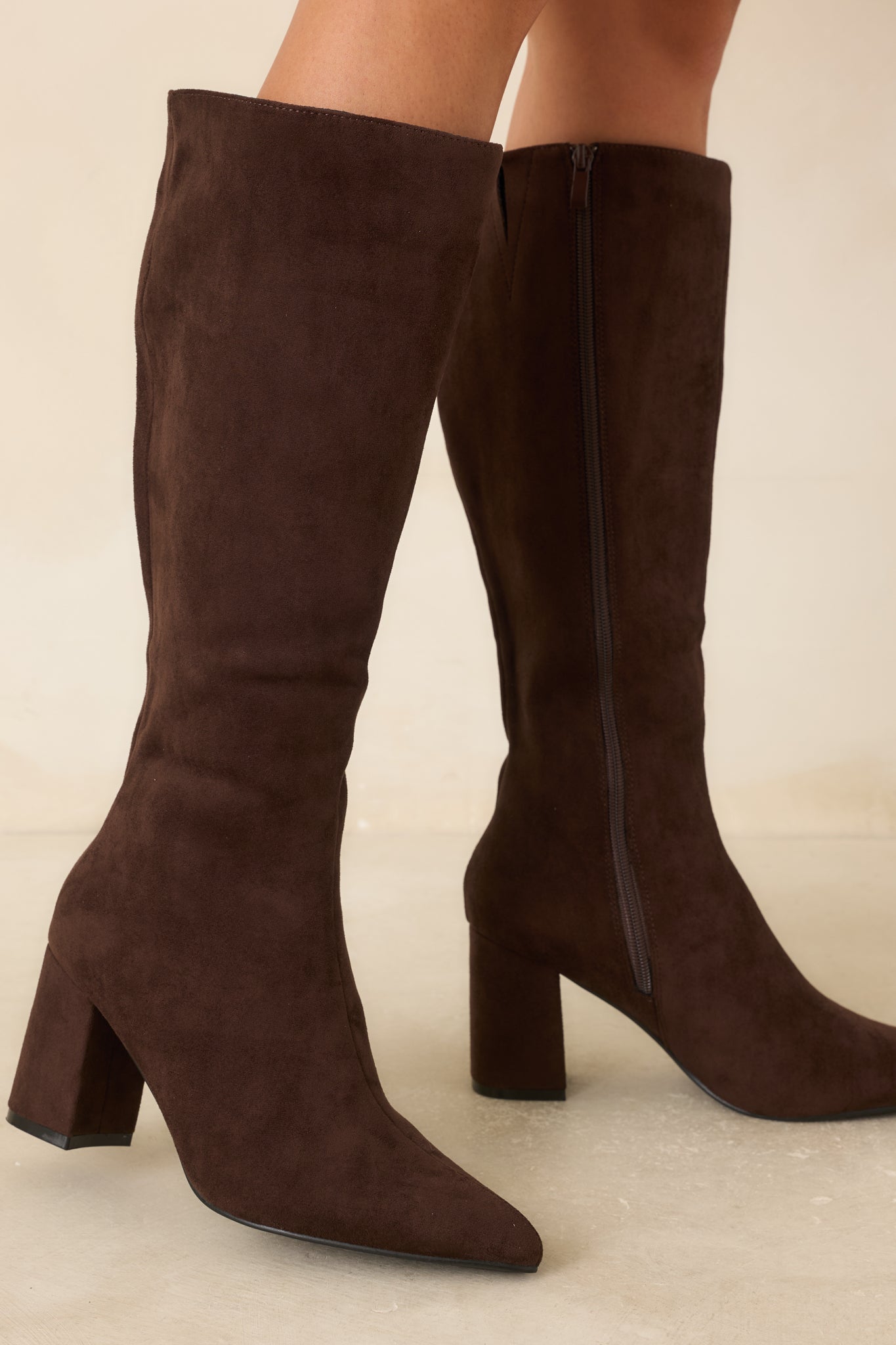Smooth faux suede knee-high boots showcasing the sleek pointed toe, fitted shaft, covered block heel, and polished deep brown finish.