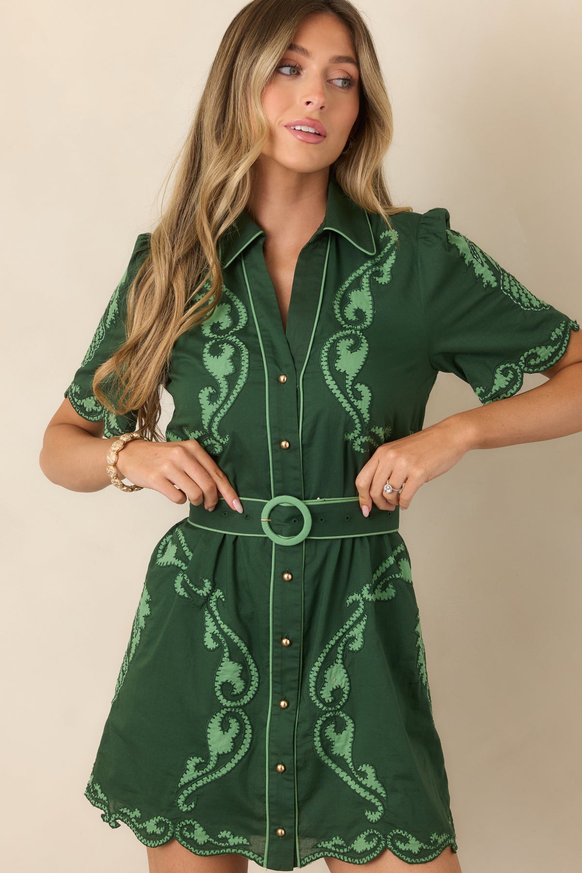 Deep green dress with a pointed collar framed by coordinating light green trim.