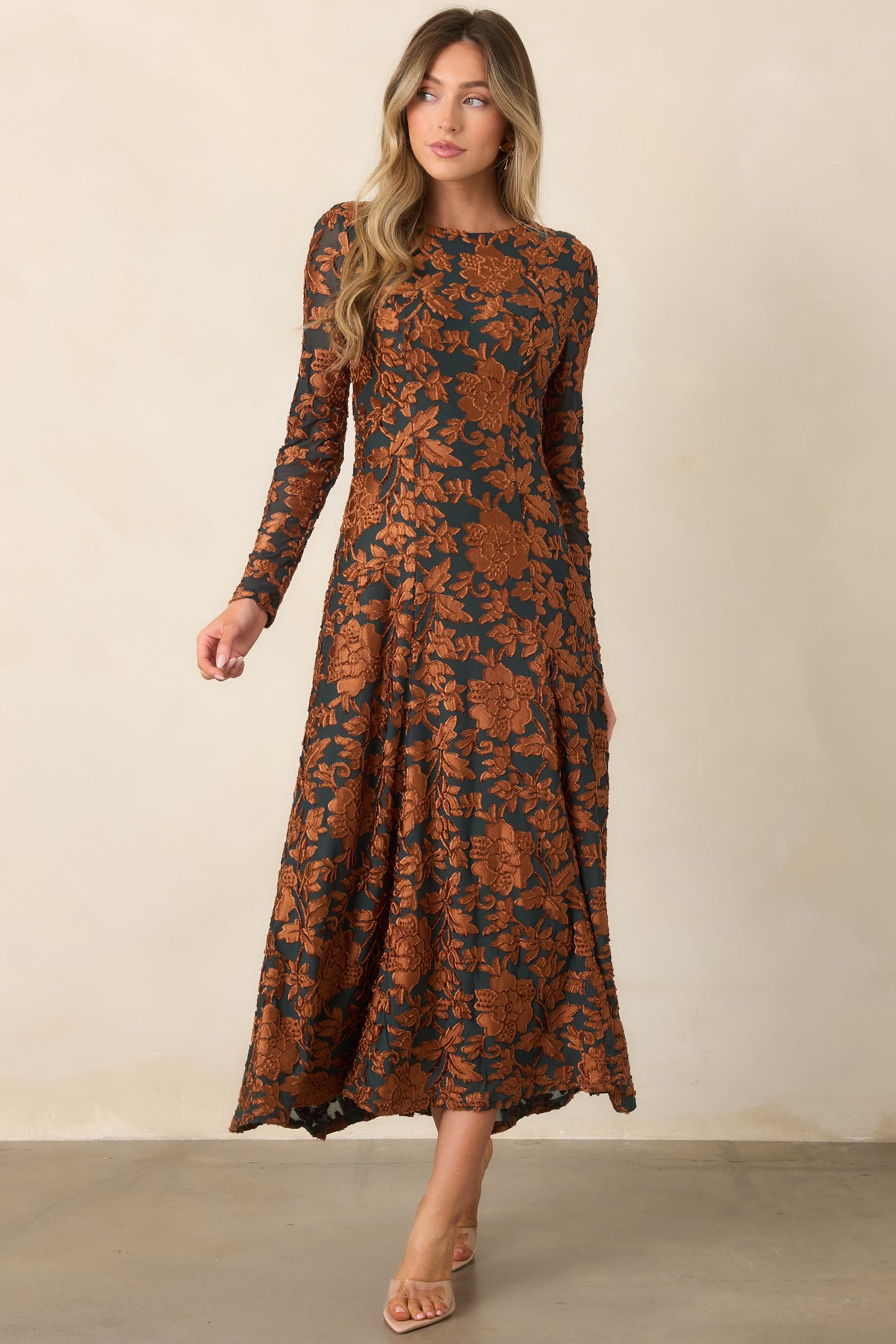 Deep green floral dress featuring dimensional copper motifs, a round neckline, and a sweeping midi-length skirt.