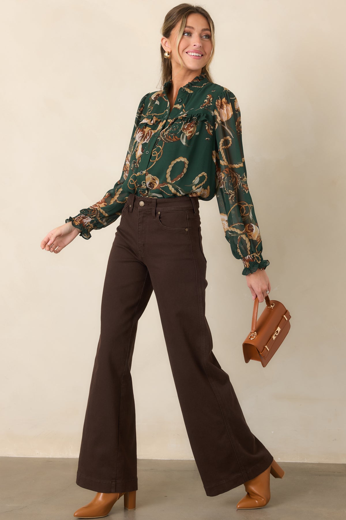 Deep green blouse showcasing its ruffle-trimmed yoke, flowing shape, button-front closure, and airy sheer sleeves.