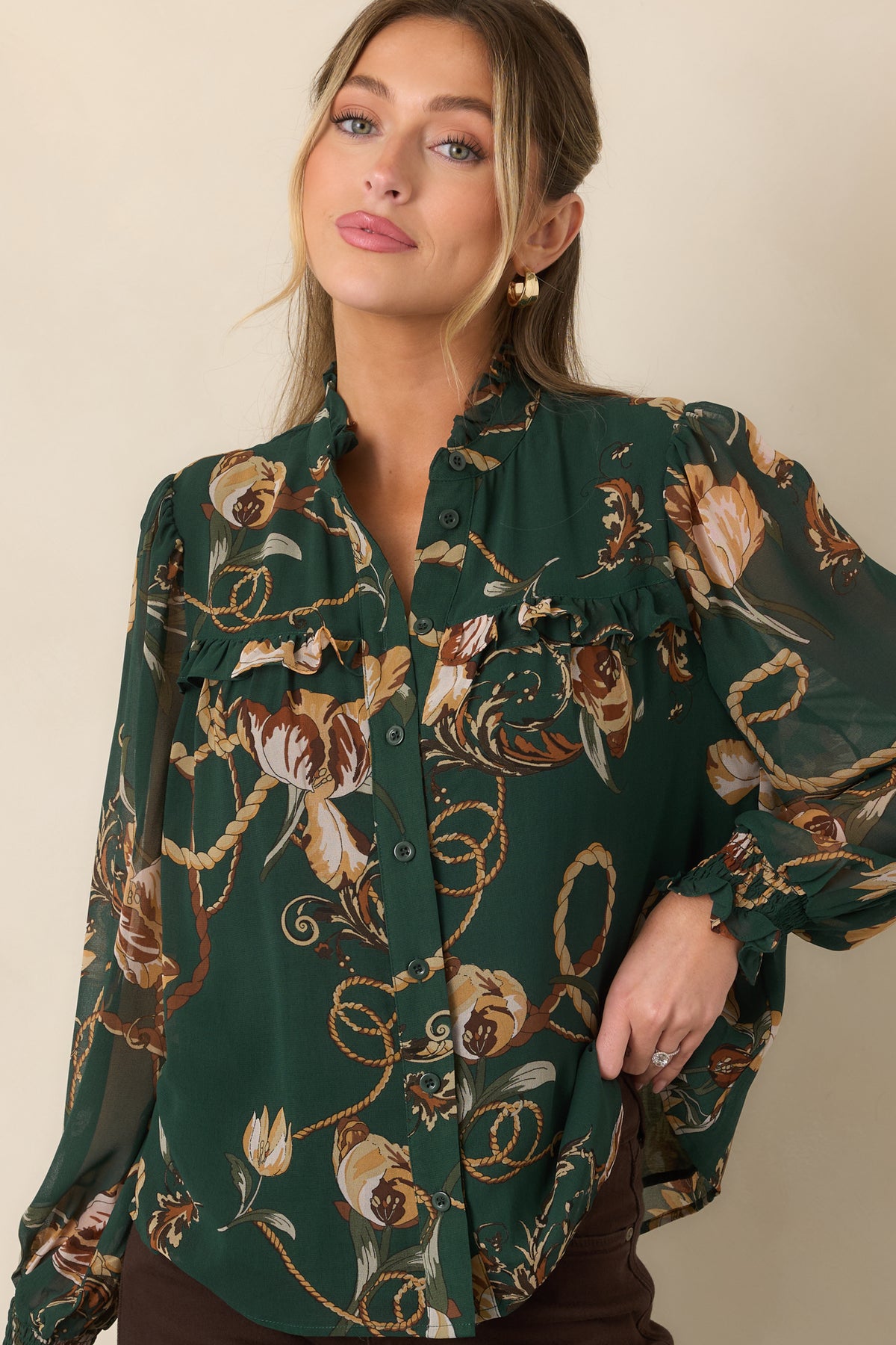 Deep green blouse highlighting the ruffled neckline, layered yoke trim, and delicate button-front construction.
