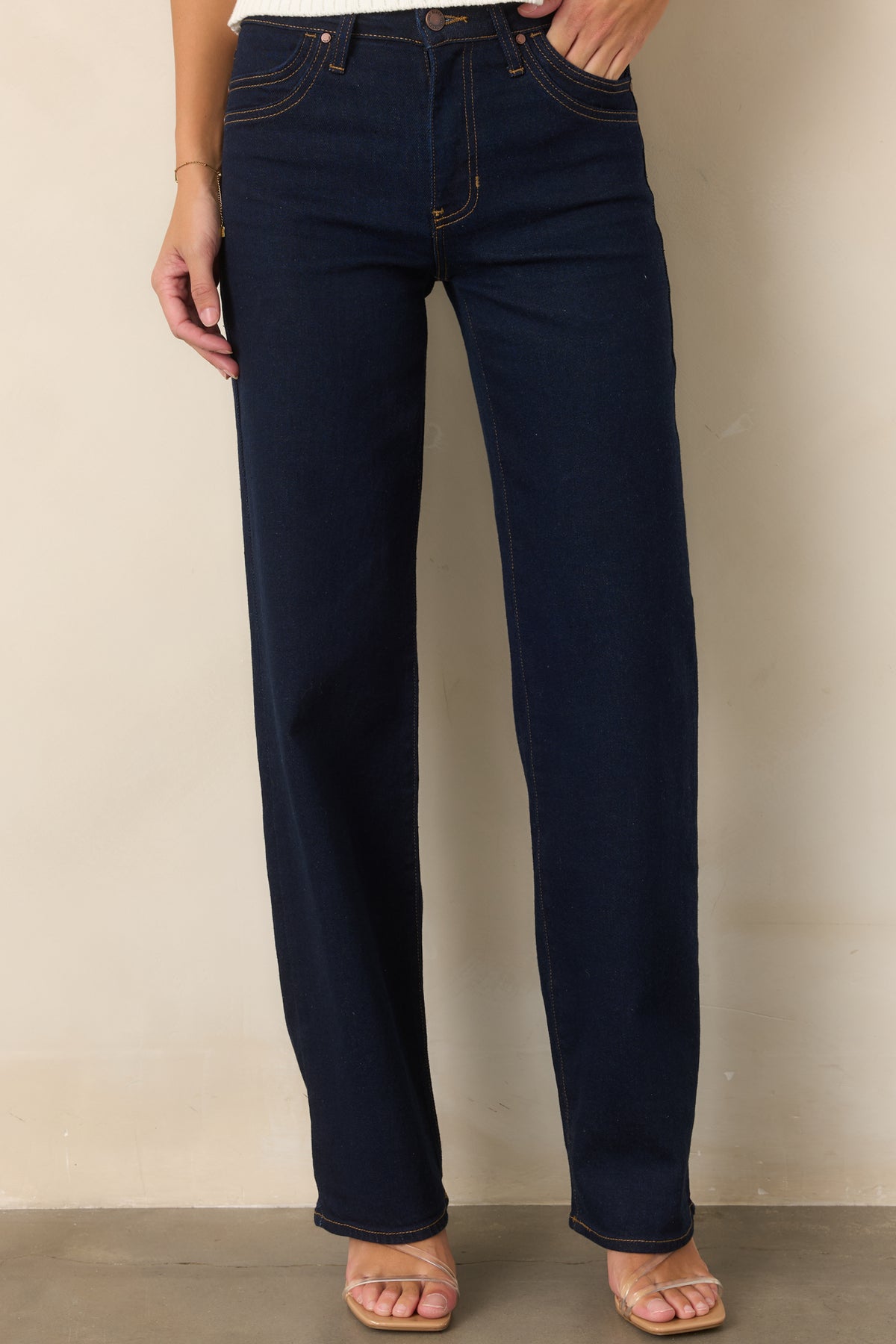 Deep indigo denim highlighting the high-rise waist and double-row pocket stitching.
