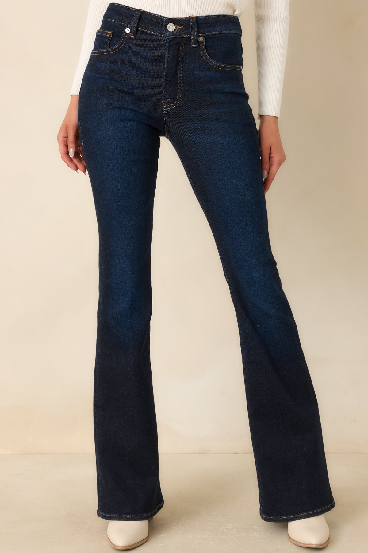 Front pockets and contrast-stitched seams detail the deep indigo jeans’ classic five-pocket design.