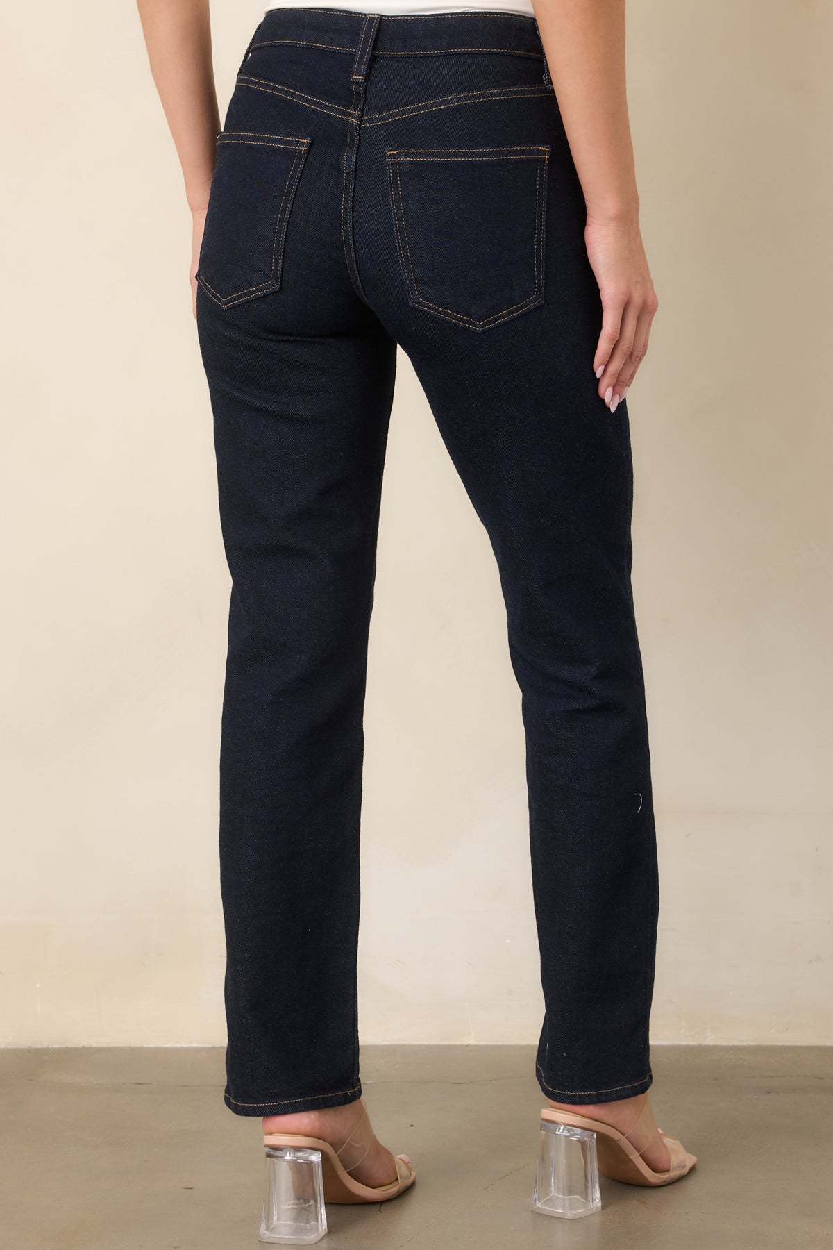 Rear view of the deep indigo jeans featuring two functional back pockets, belt loops, high-rise construction, and straight legs.
