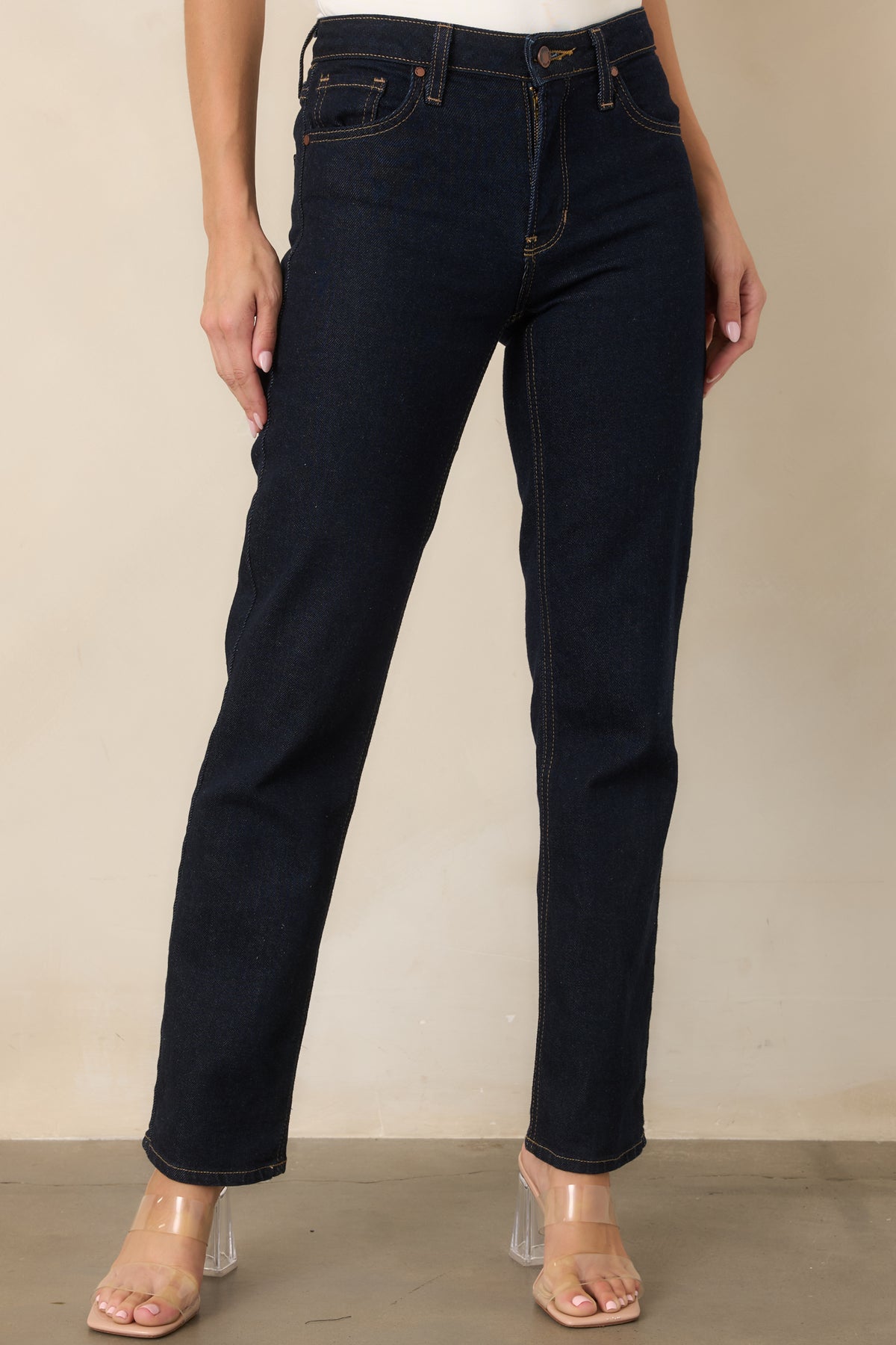 Deep indigo straight-leg jeans emphasizing the clean leg line and evenly finished denim hem.