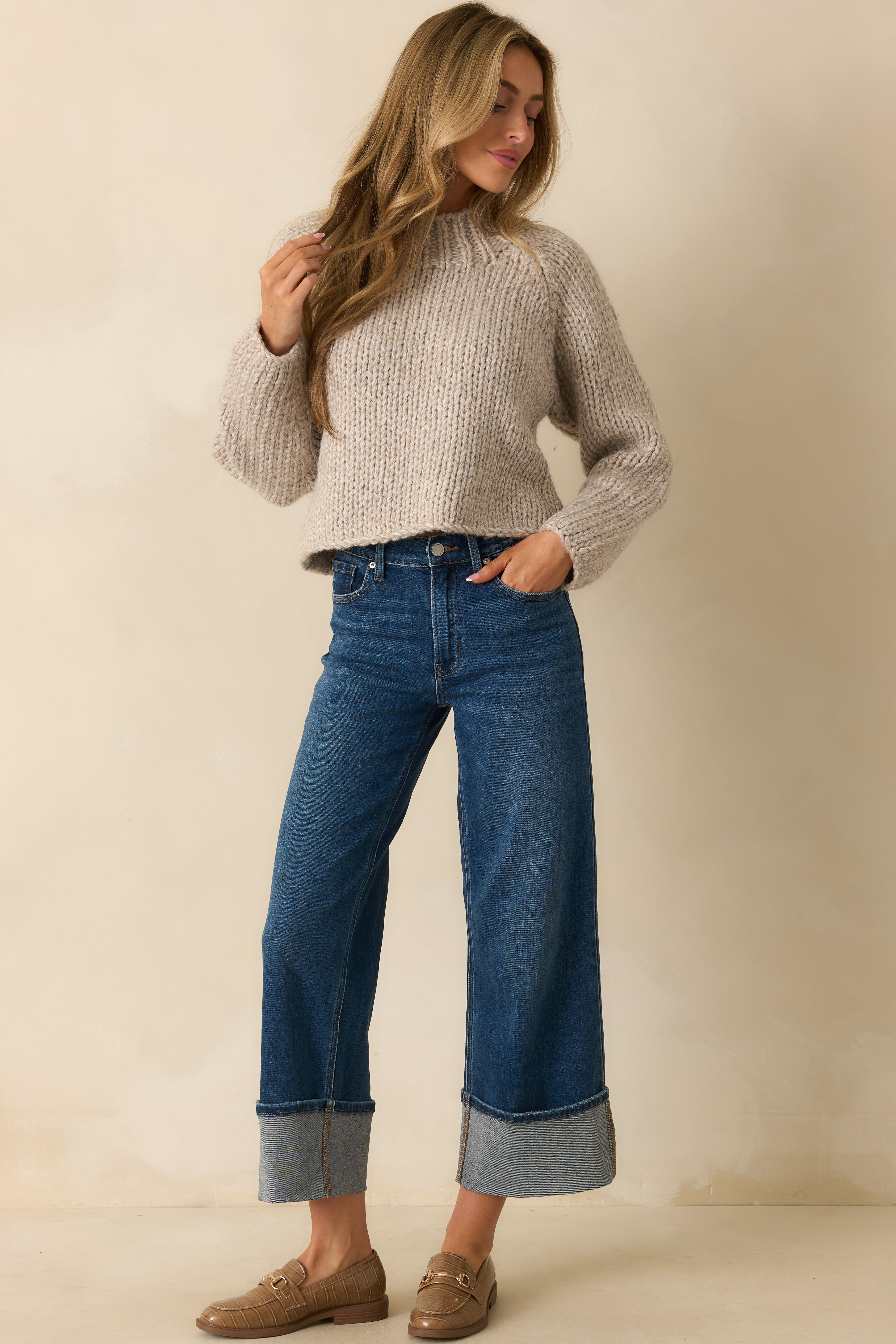 Front view of deep indigo wide-leg jeans showing the high-rise waist and exaggerated cuffed hems.