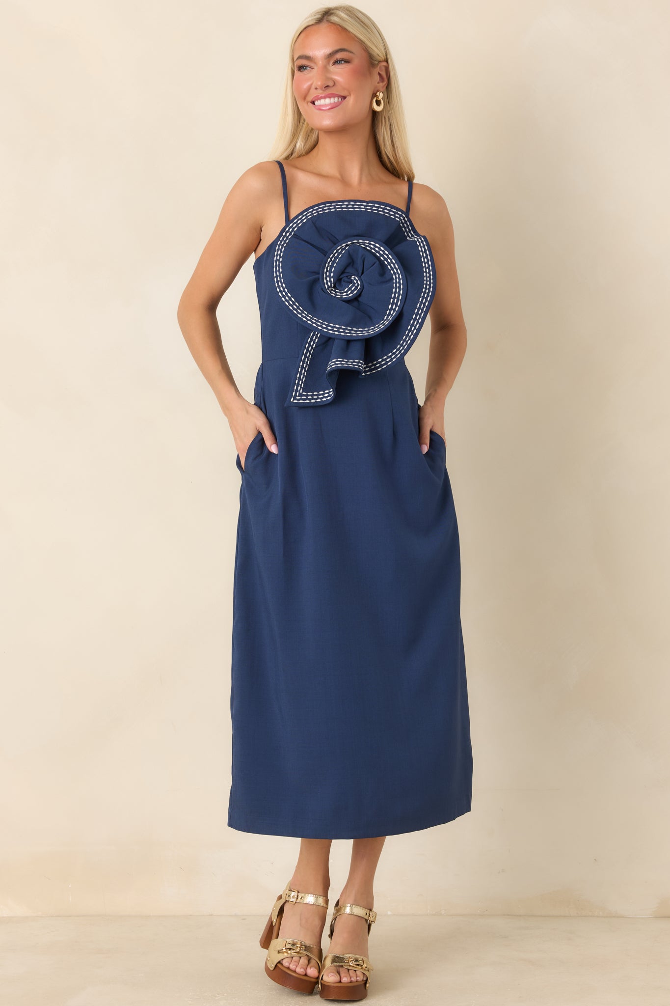 Midi dress featuring a deep navy base, oversized floral detailing, and a polished, structured shape.
