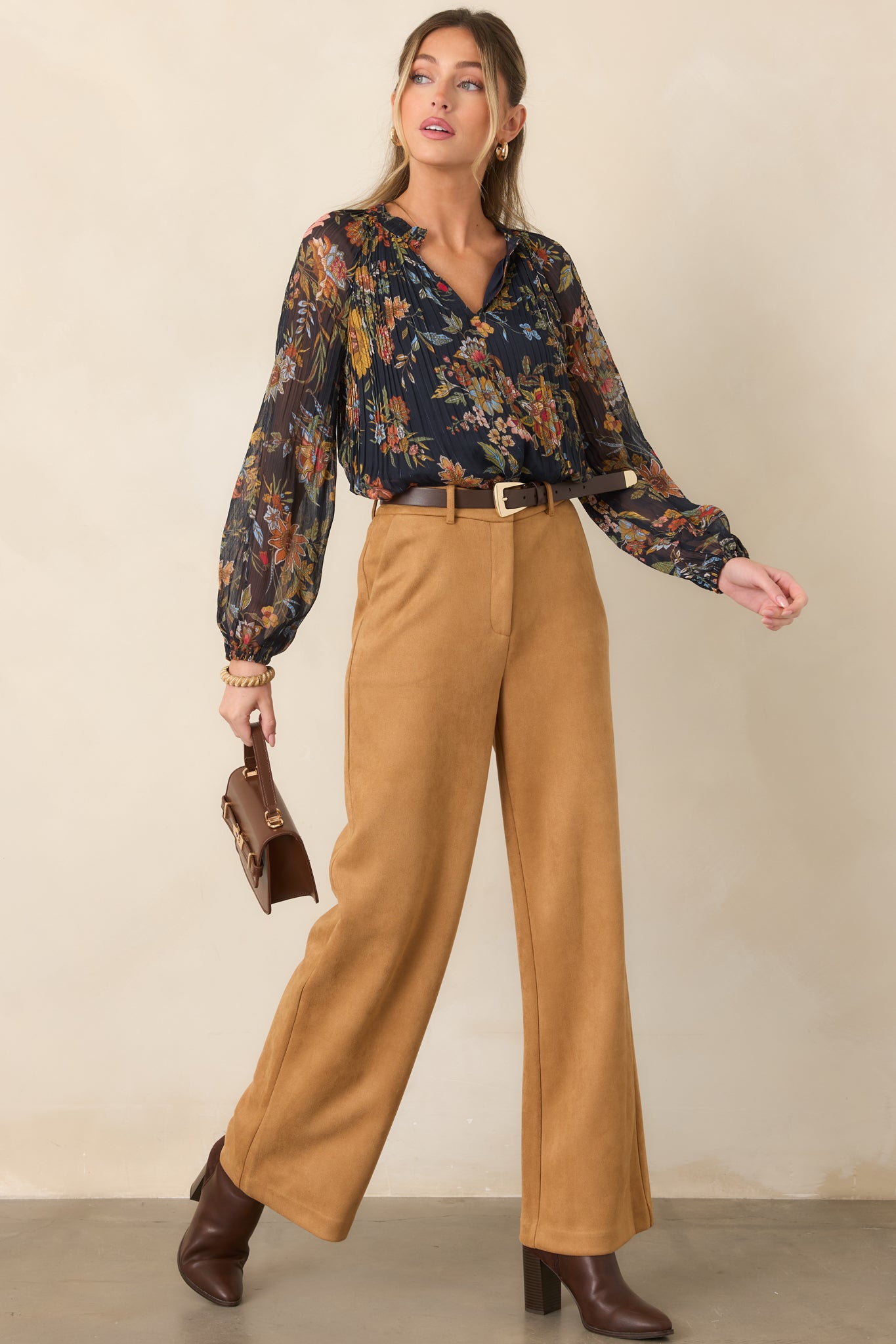 Deep navy blouse highlighting its finely pleated texture, colorful botanical pattern, and softly flowing long sleeves.
