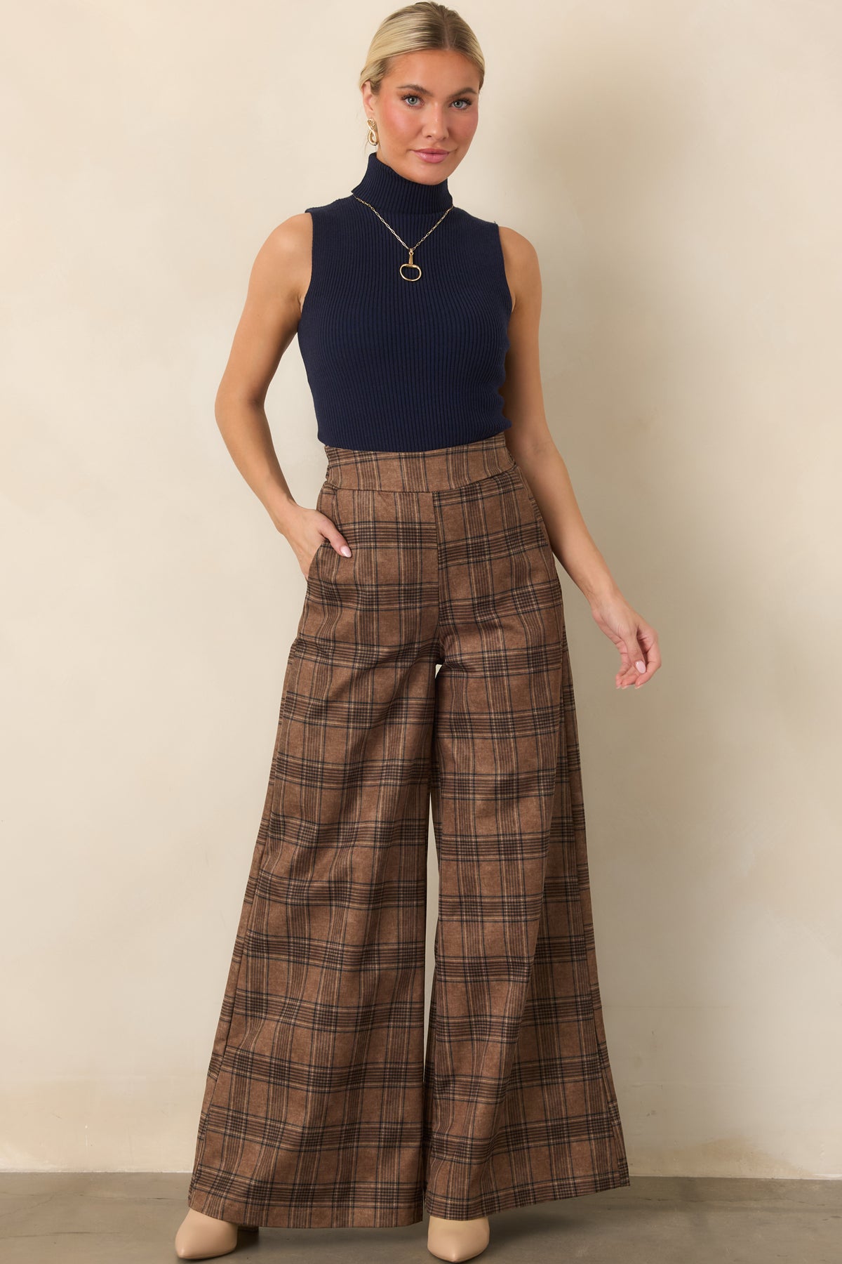 Deep navy ribbed knit top with a fitted silhouette, sleeveless cut, full fold-over turtleneck, and hip-length hem.
