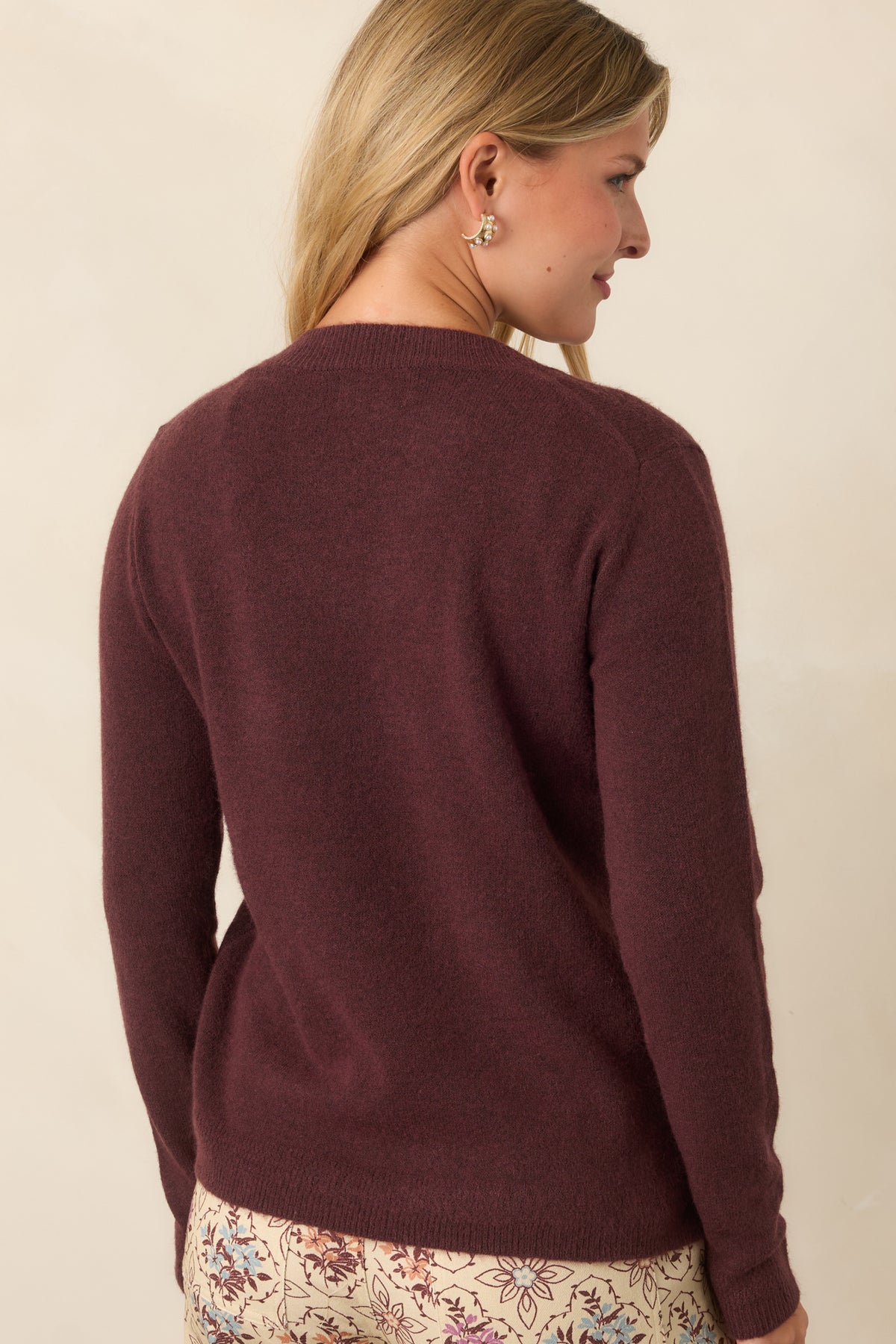 Rear of the deep raisin knit top showcasing its long sleeves and ribbed hem.