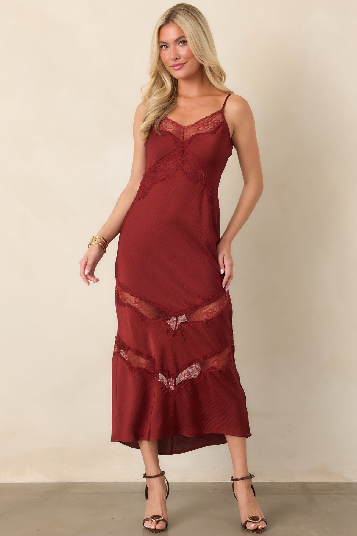Deep red crinkled satin dress with floral lace detailing across the bodice and geometric lace accents on the midi skirt