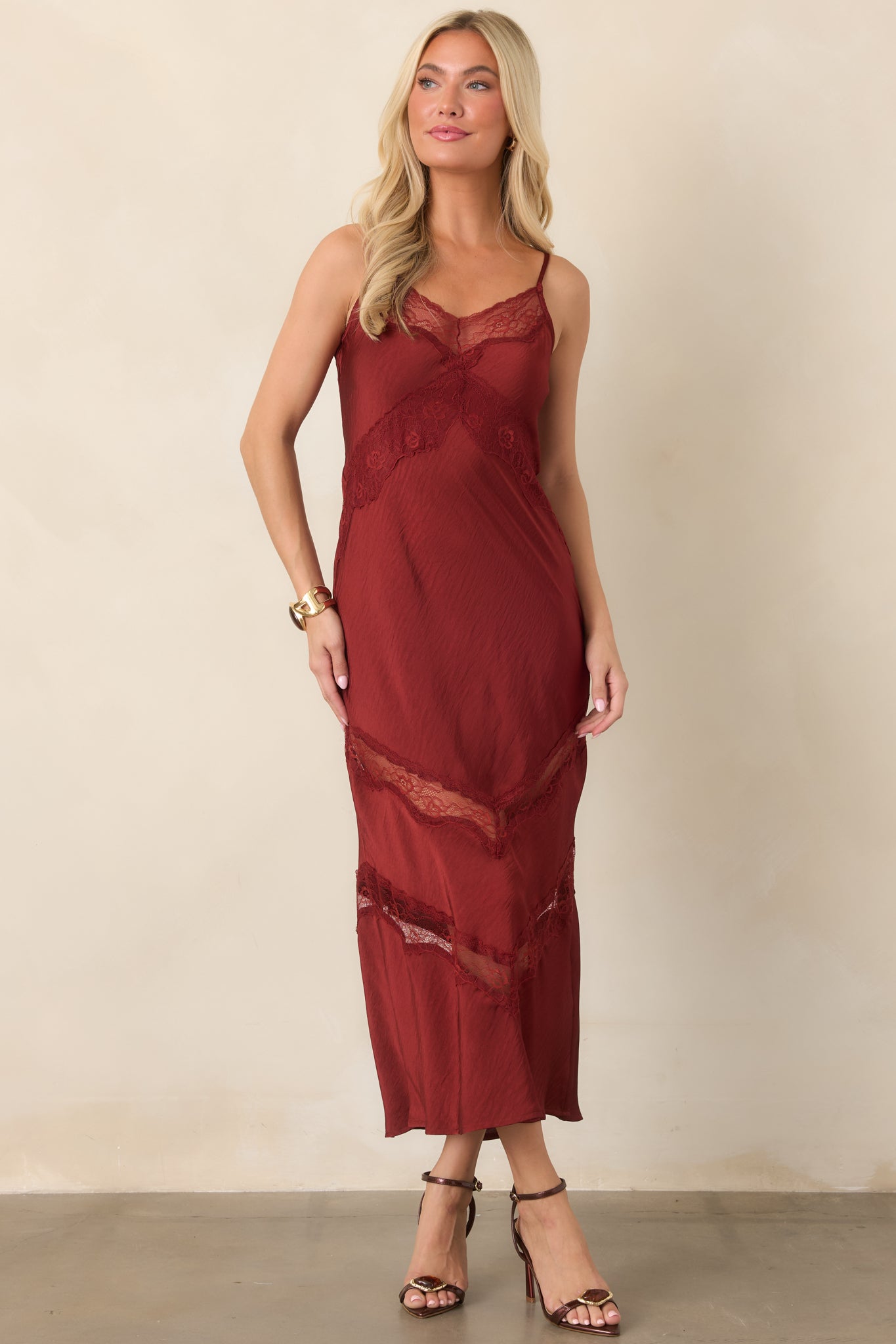 Deep red satin midi dress with adjustable spaghetti straps, lace-trimmed V-neckline, and tonal chevron lace insets