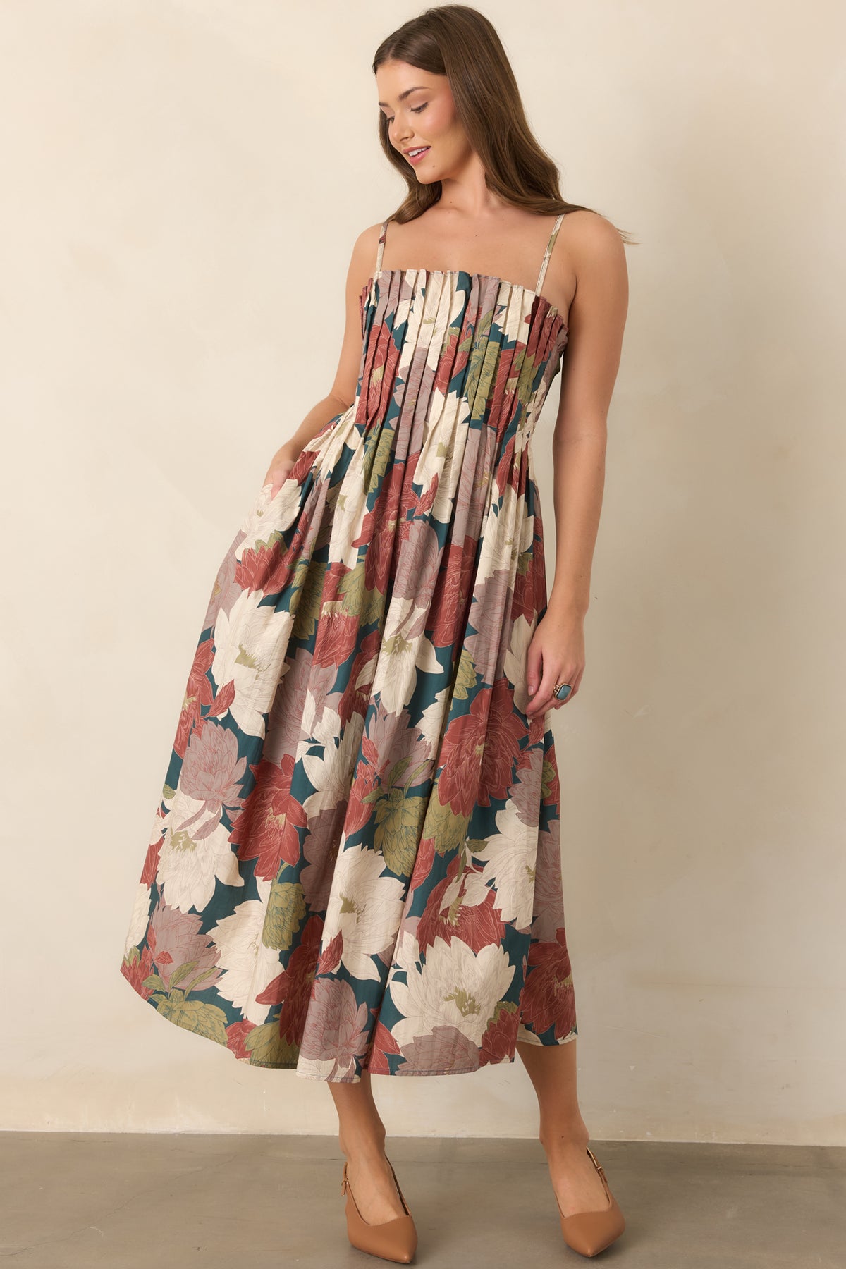 Deep teal floral cotton dress with a defined waist, full A-line skirt, and adjustable straps.
