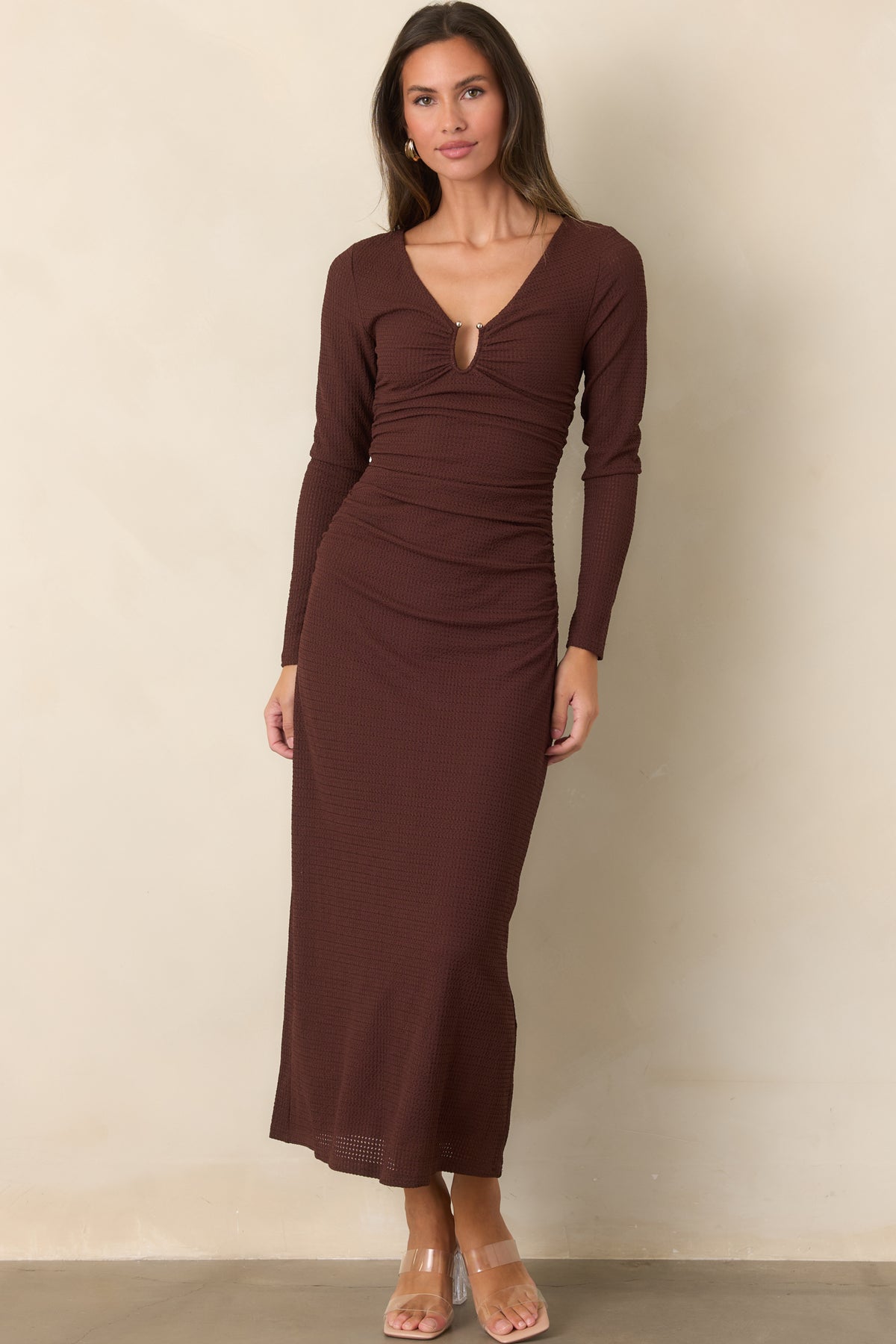 Deep V-neckline frames the textured dress, with a metallic-accented keyhole and softly gathered details through the waist.
