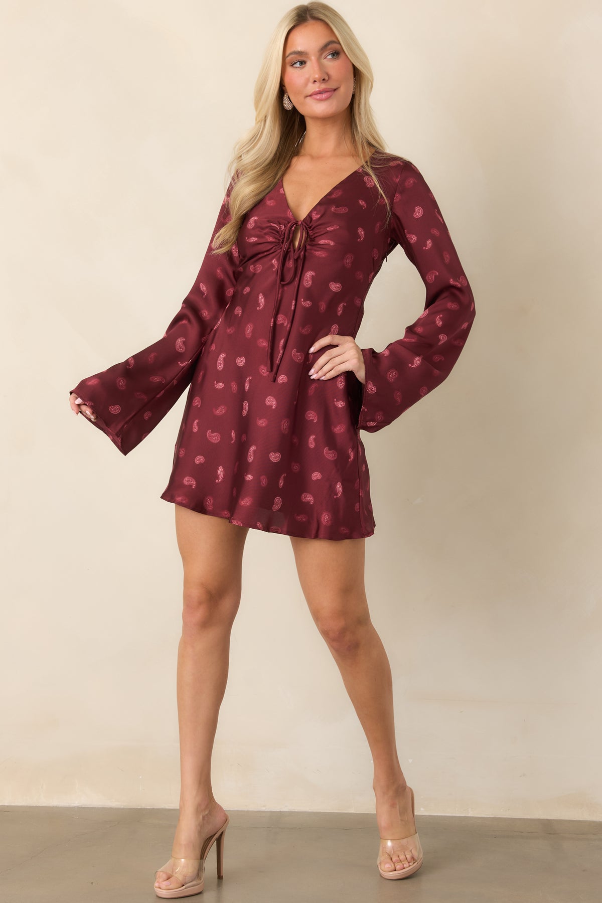Deep wine mini dress showcasing long flared sleeves and a gently flared skirt.