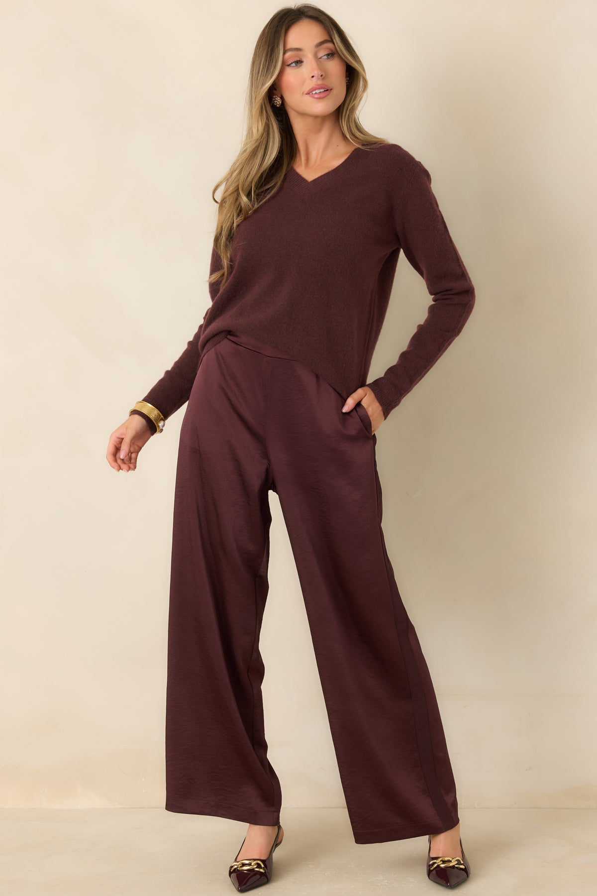 Deep wine satin pants with plum undertones, a softly textured finish, and flowing wide legs.