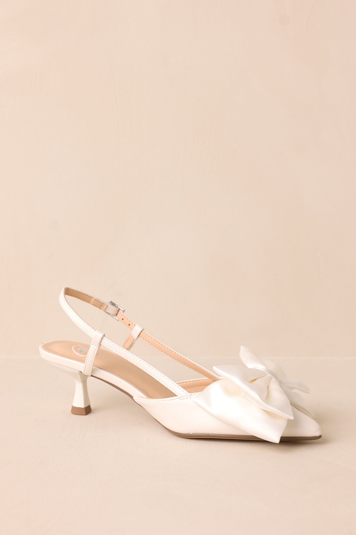 Smooth white material and a delicate slingback strap give this kitten heel a polished, sophisticated look.
