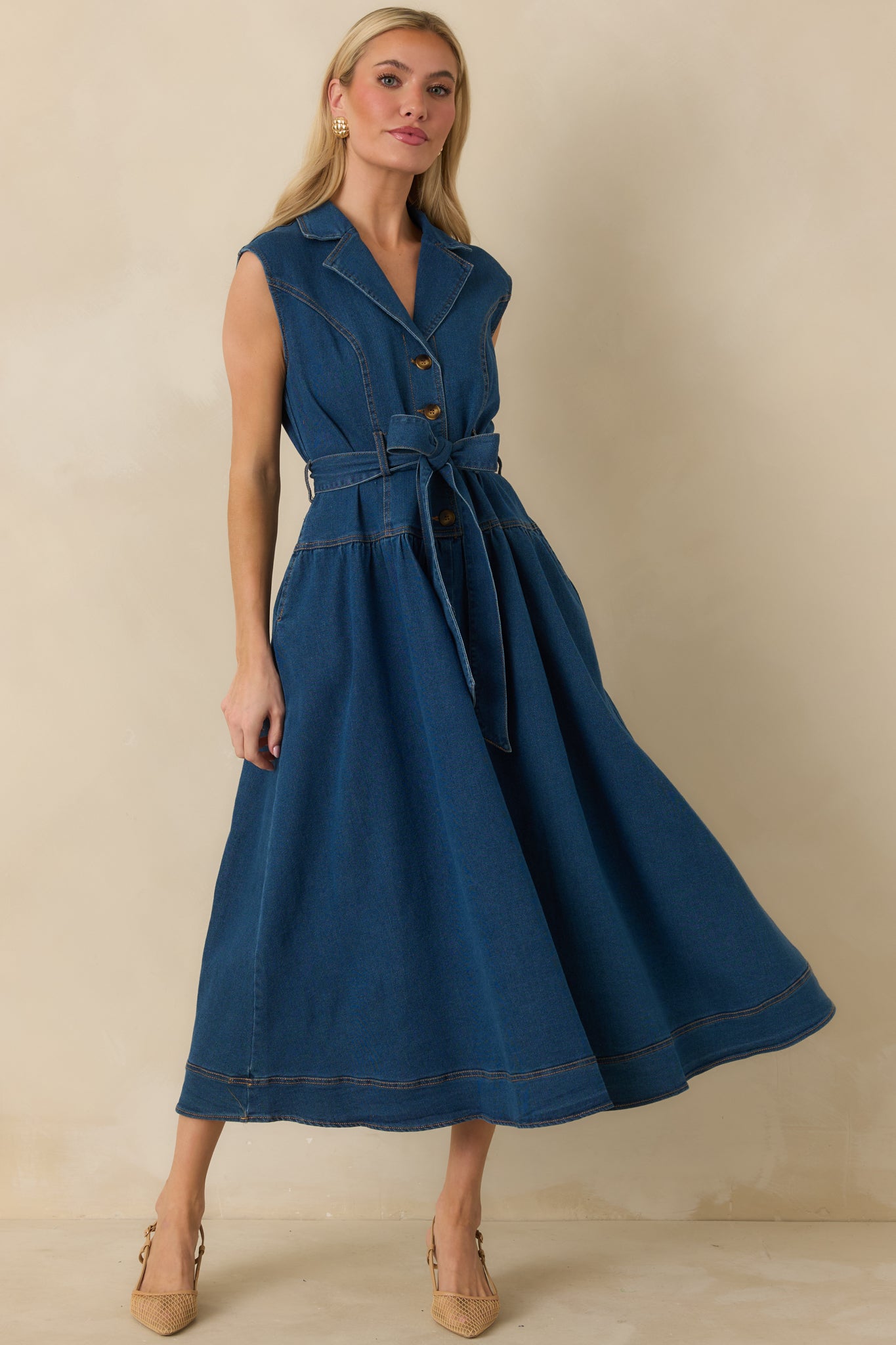 Denim dress with collared neckline, adjustable waist tie, and subtle seam detailing for a tailored fit.