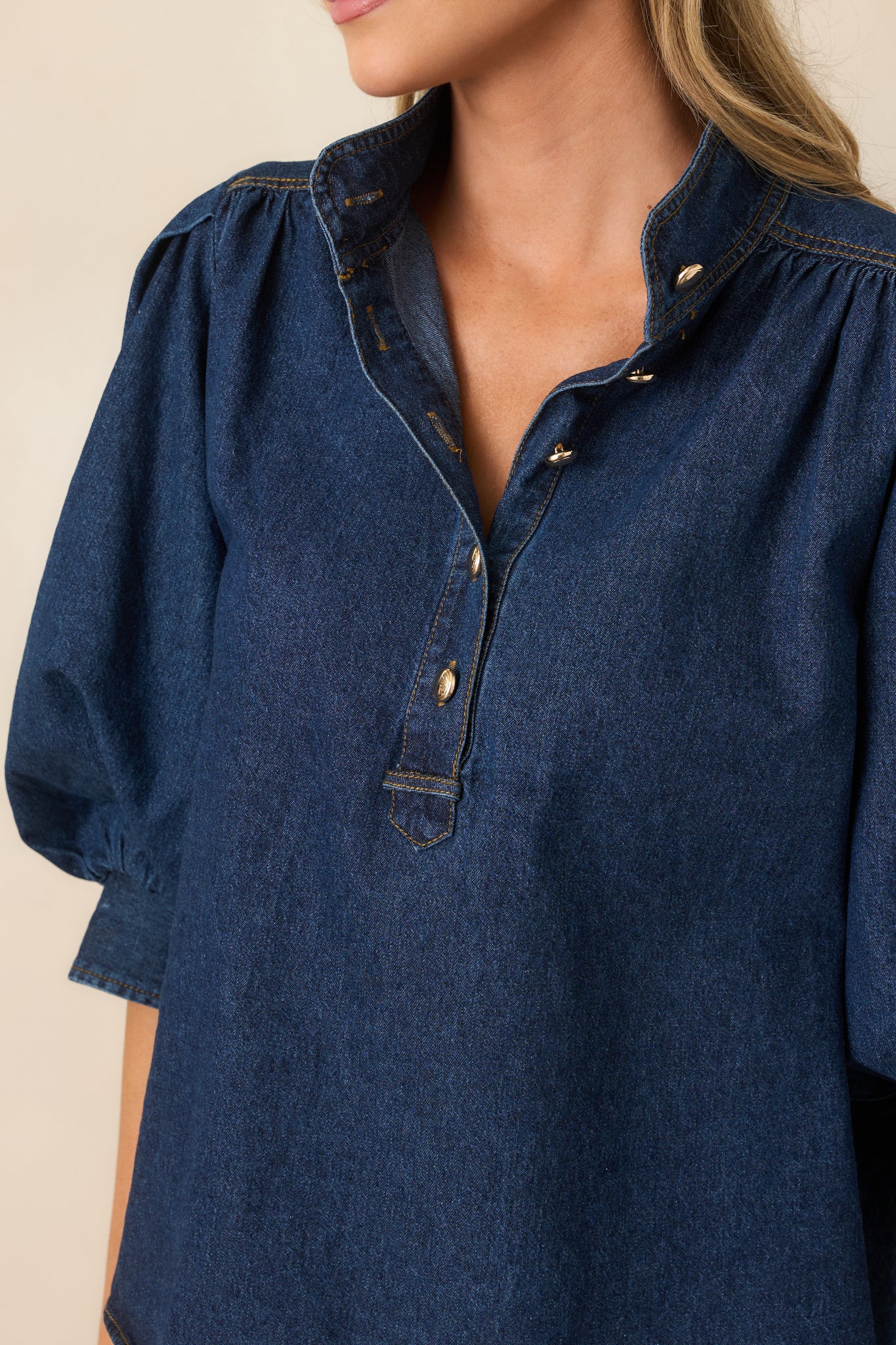 Close-up highlights the cotton-blend denim, gathered shoulder, partial button placket, and adjustable balloon sleeve cuff.