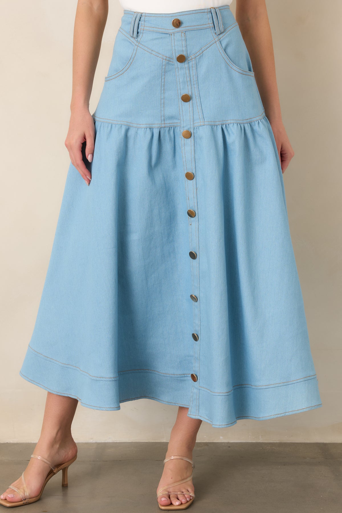 Close view of the wide denim hem and gathered tier, highlighting the skirt’s structured fabric and graceful movement.