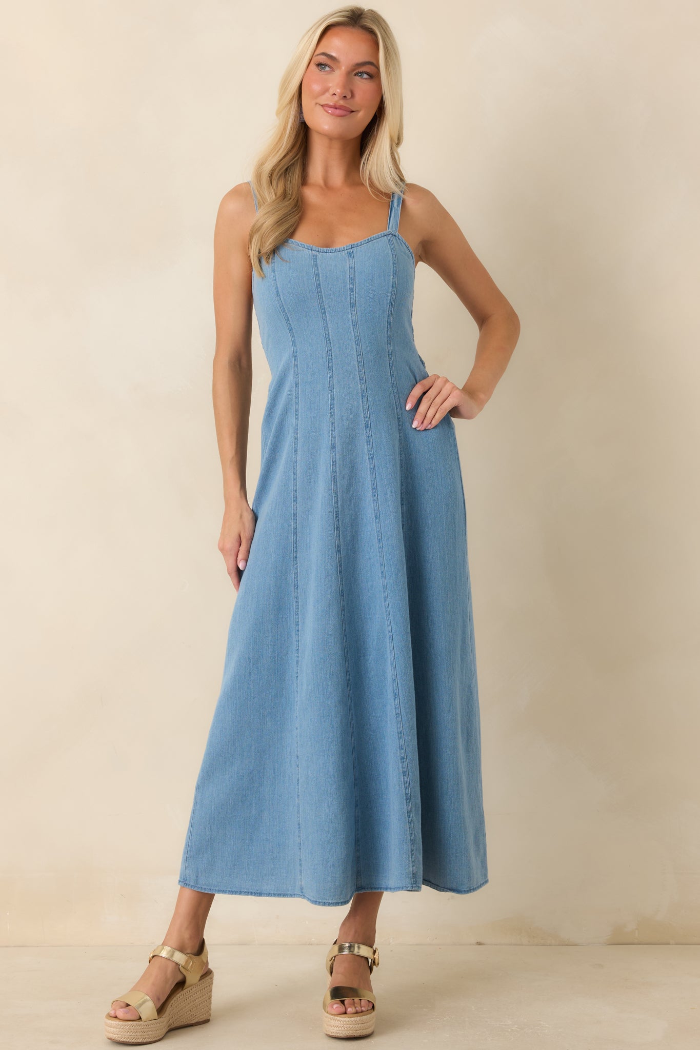 Denim midi dress designed with a fitted bodice, gently flared skirt, and vertical seaming details.