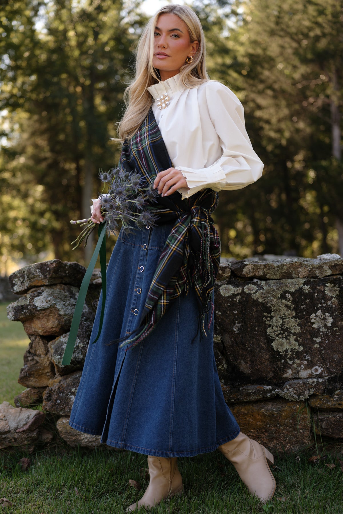 Denim midi skirt with a flared A-line silhouette, gold-tone front buttons, and contrast stitching.