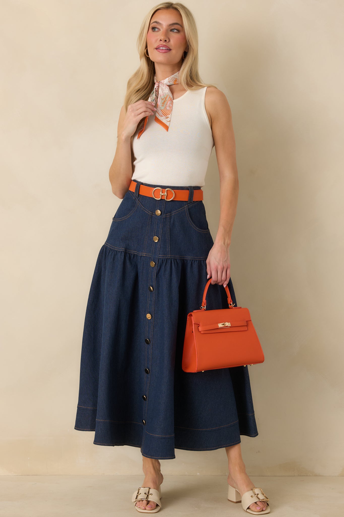 Straight-on view of the dark wash denim skirt emphasizing the contrast topstitching and tailored fit.