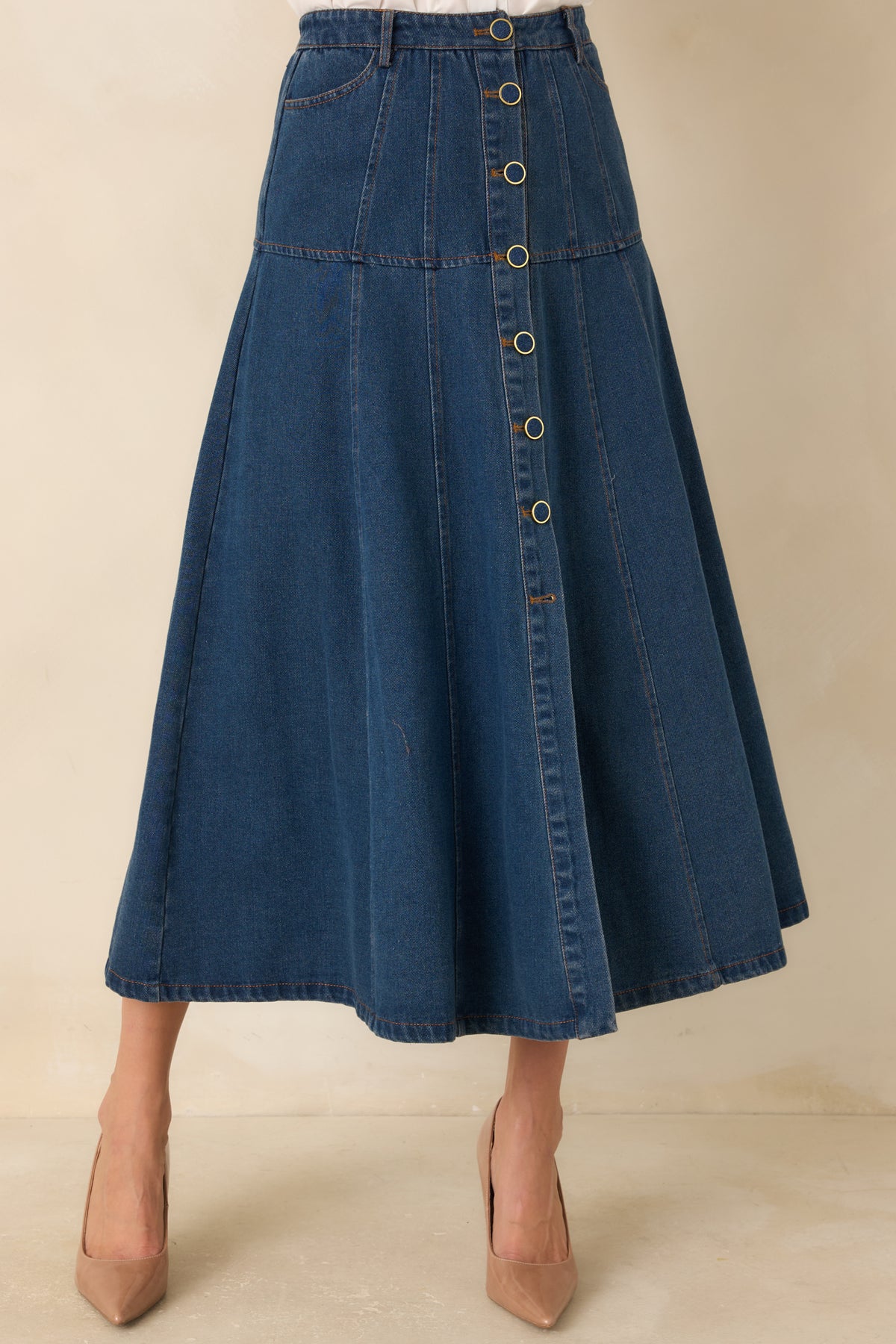 Paneled denim seams create definition through the flared skirt silhouette.