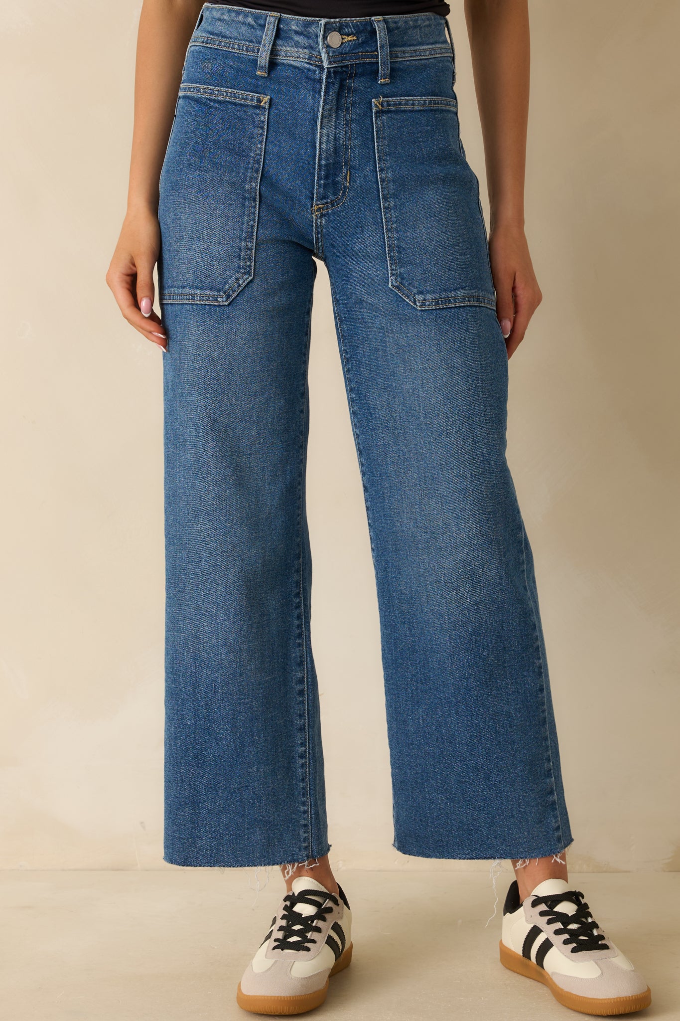 Detail of belt loops and fabric texture on wide-leg medium wash jeans.
