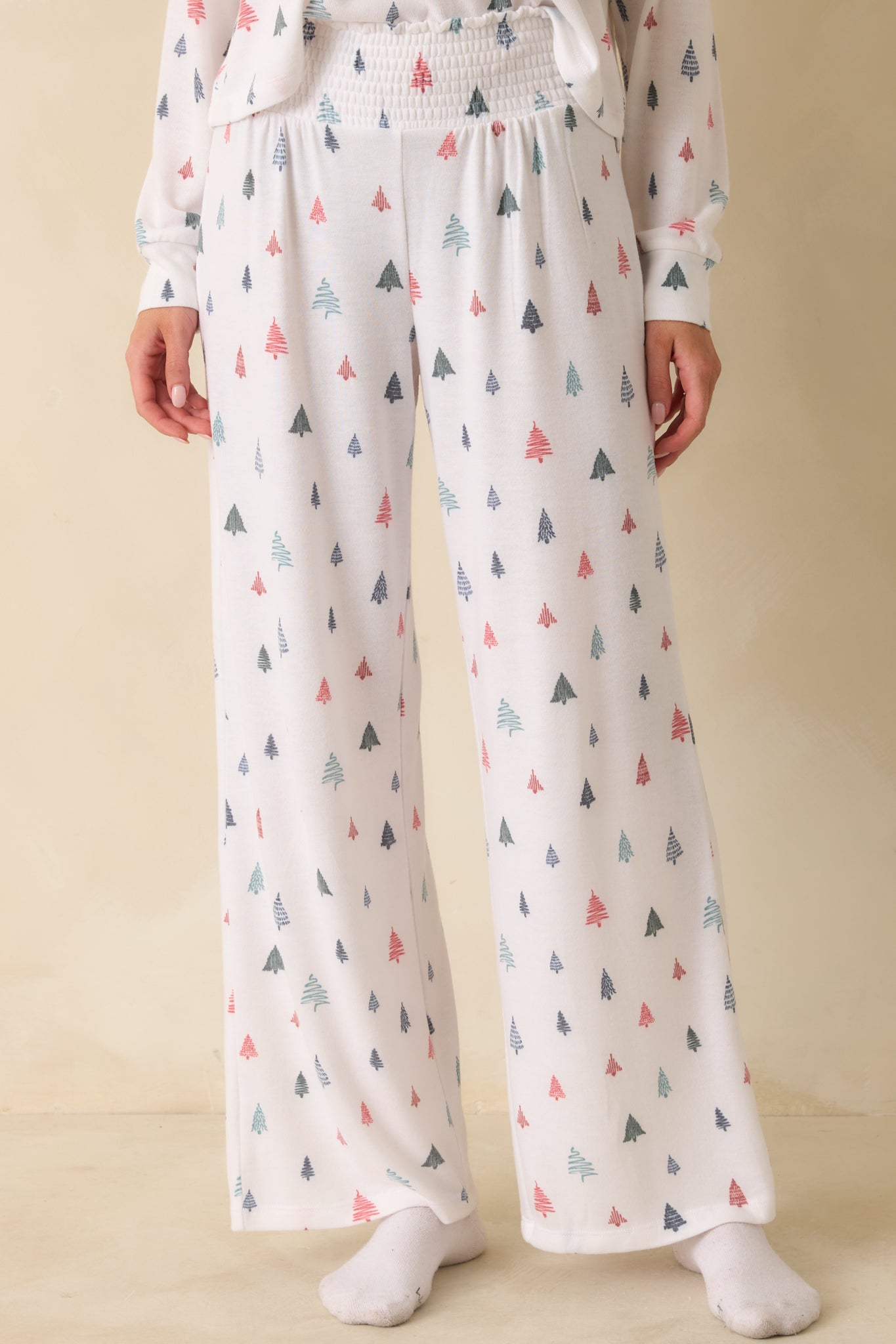 Detail of front of white multi pajama pants, emphasizing smocked waistband, wide-leg cut, and brushed knit texture.