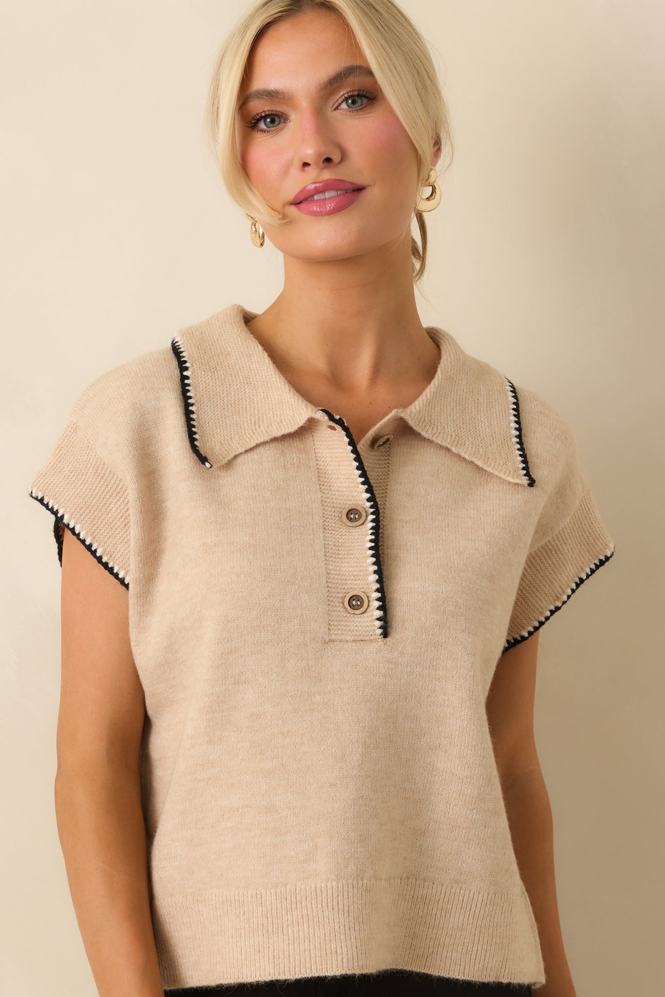 Detail of the functional buttons and black whipstitch trim along the front closure.
