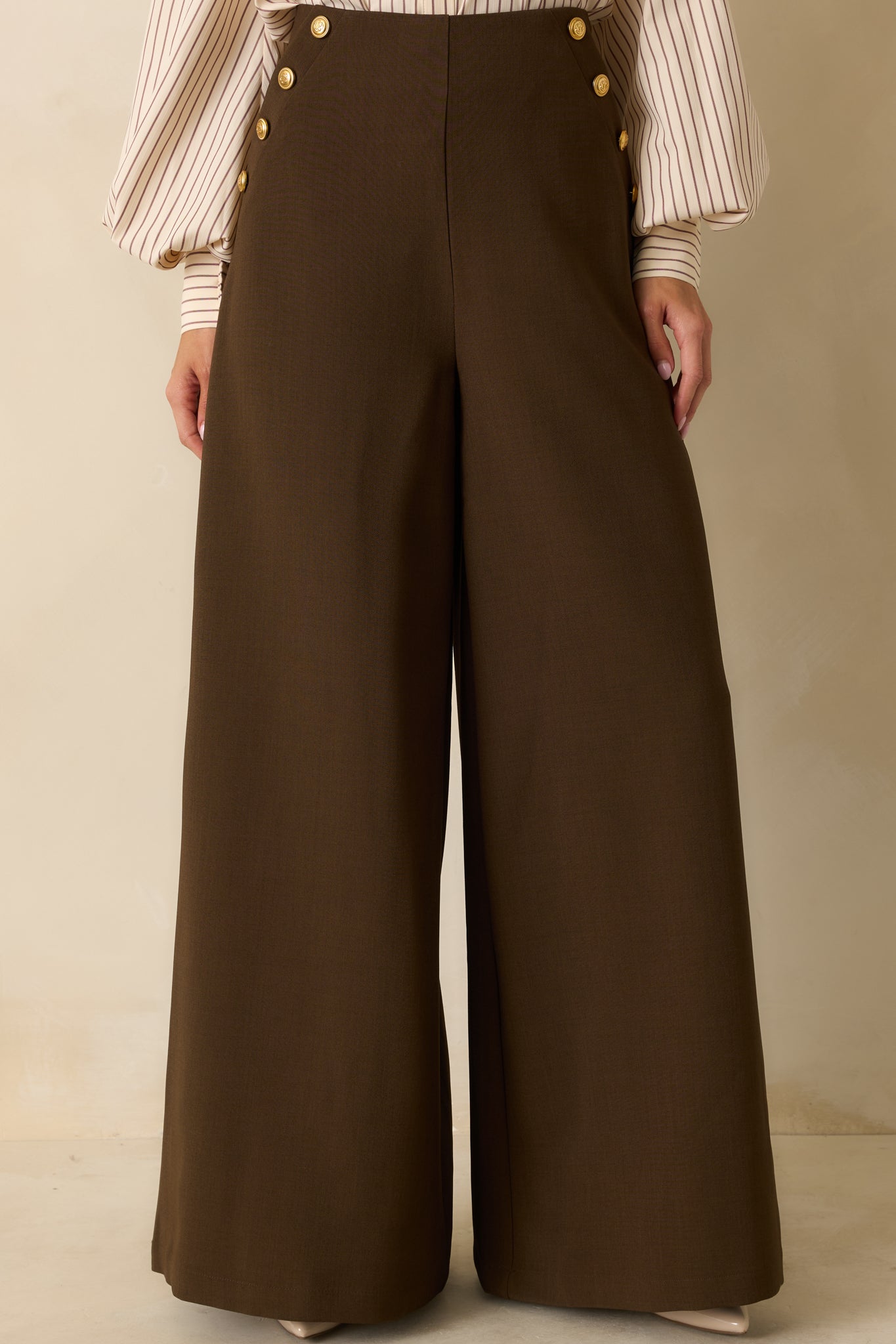 Detail of hip area showing embossed gold buttons and clean seam finish.