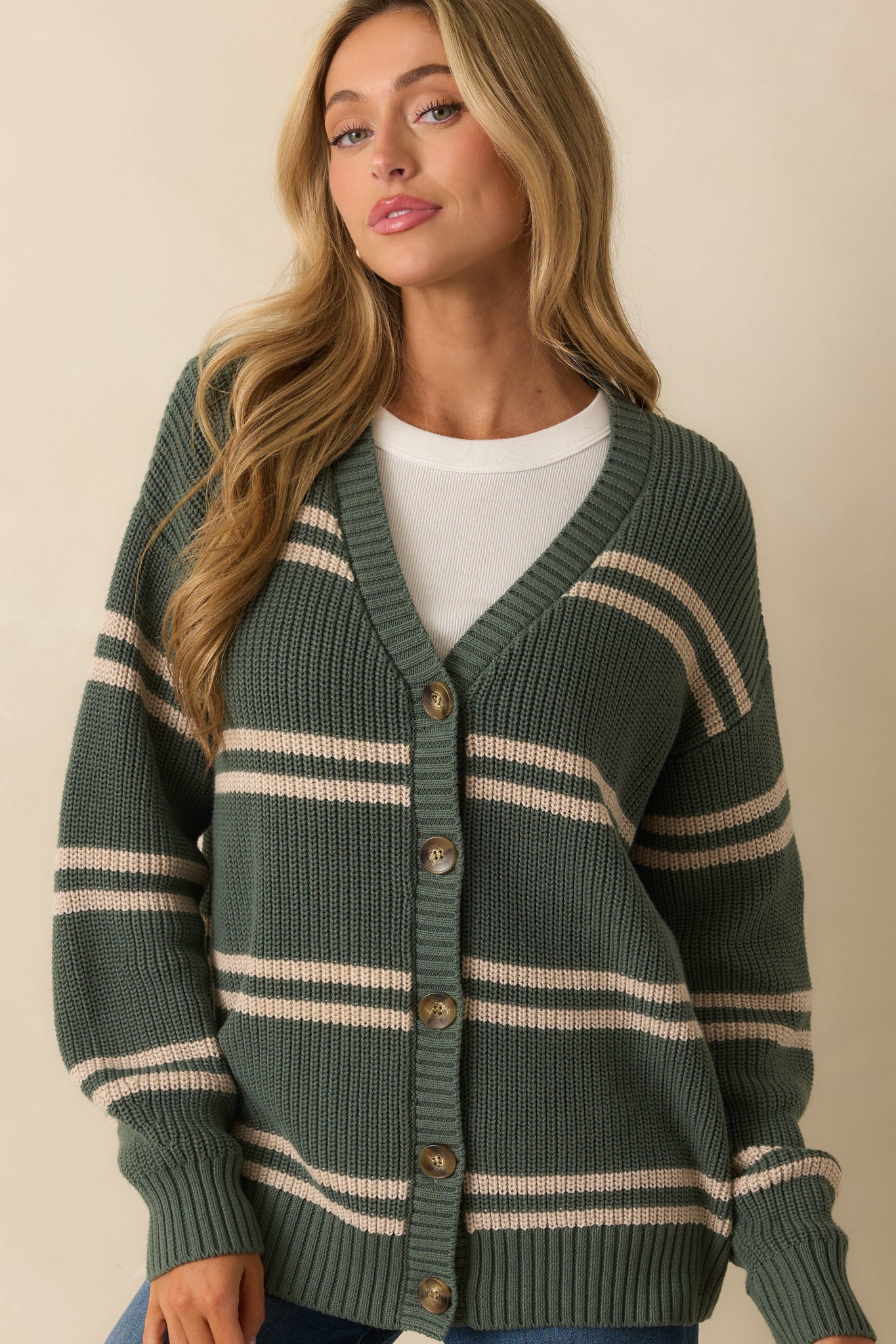 Detail of the horizontal beige stripes and ribbed texture along the sleeves.