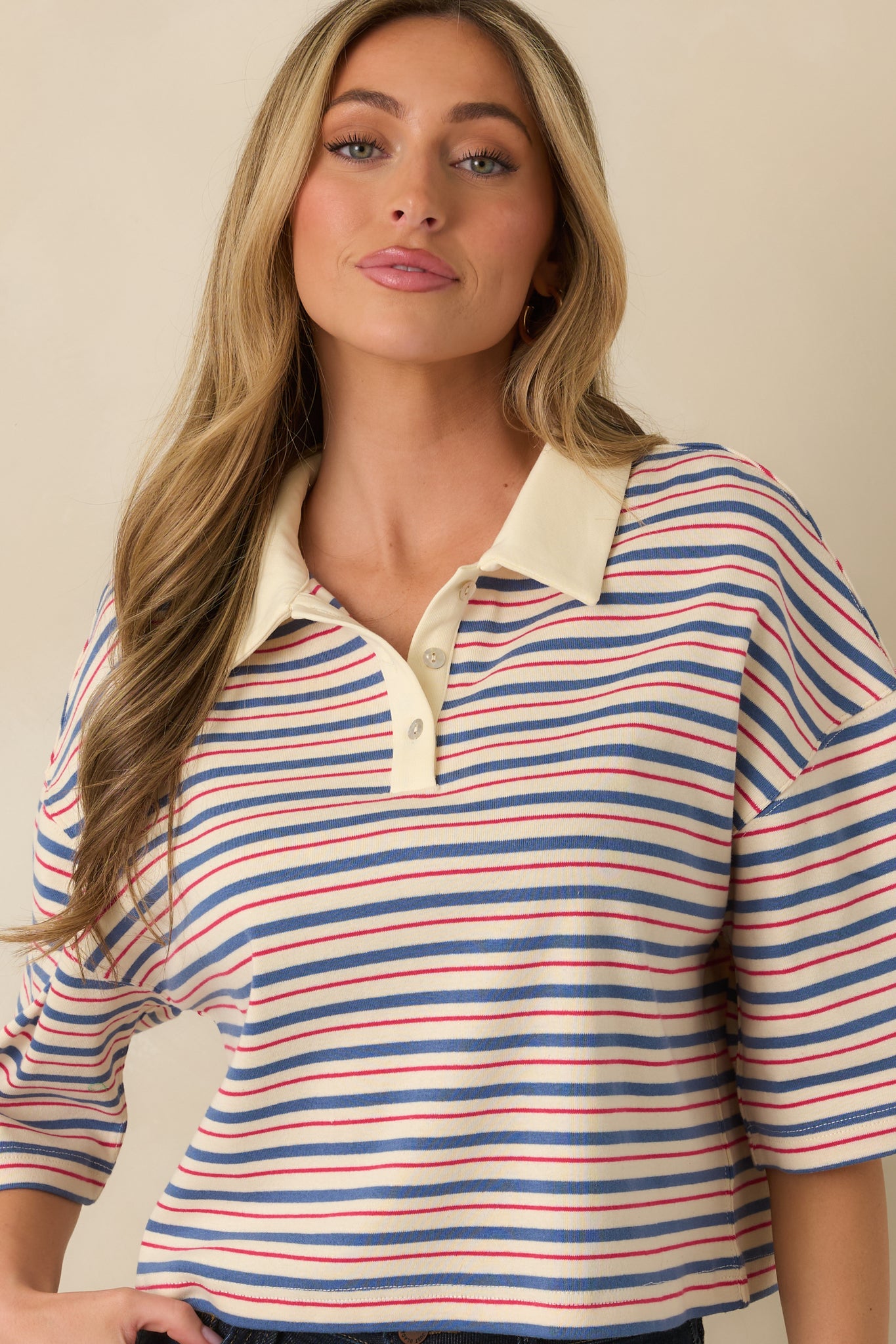 Detail of short drop-shoulder sleeve and relaxed boxy fit in multi-stripe fabric.