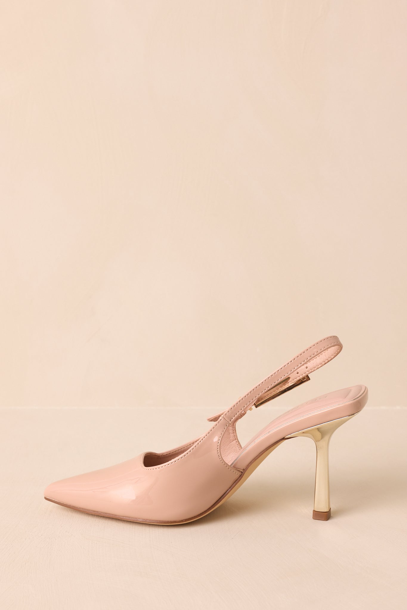 Detail of pointed toe and glossy patent finish on the heels.