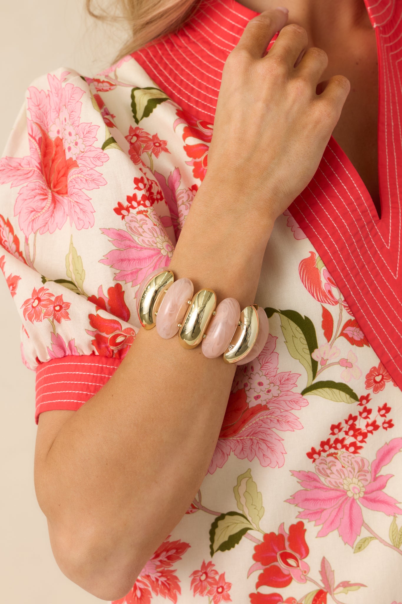 Close-up detail of the bracelet beads showing the faux rose quartz appearance of the pink beads and reflective gold accents.