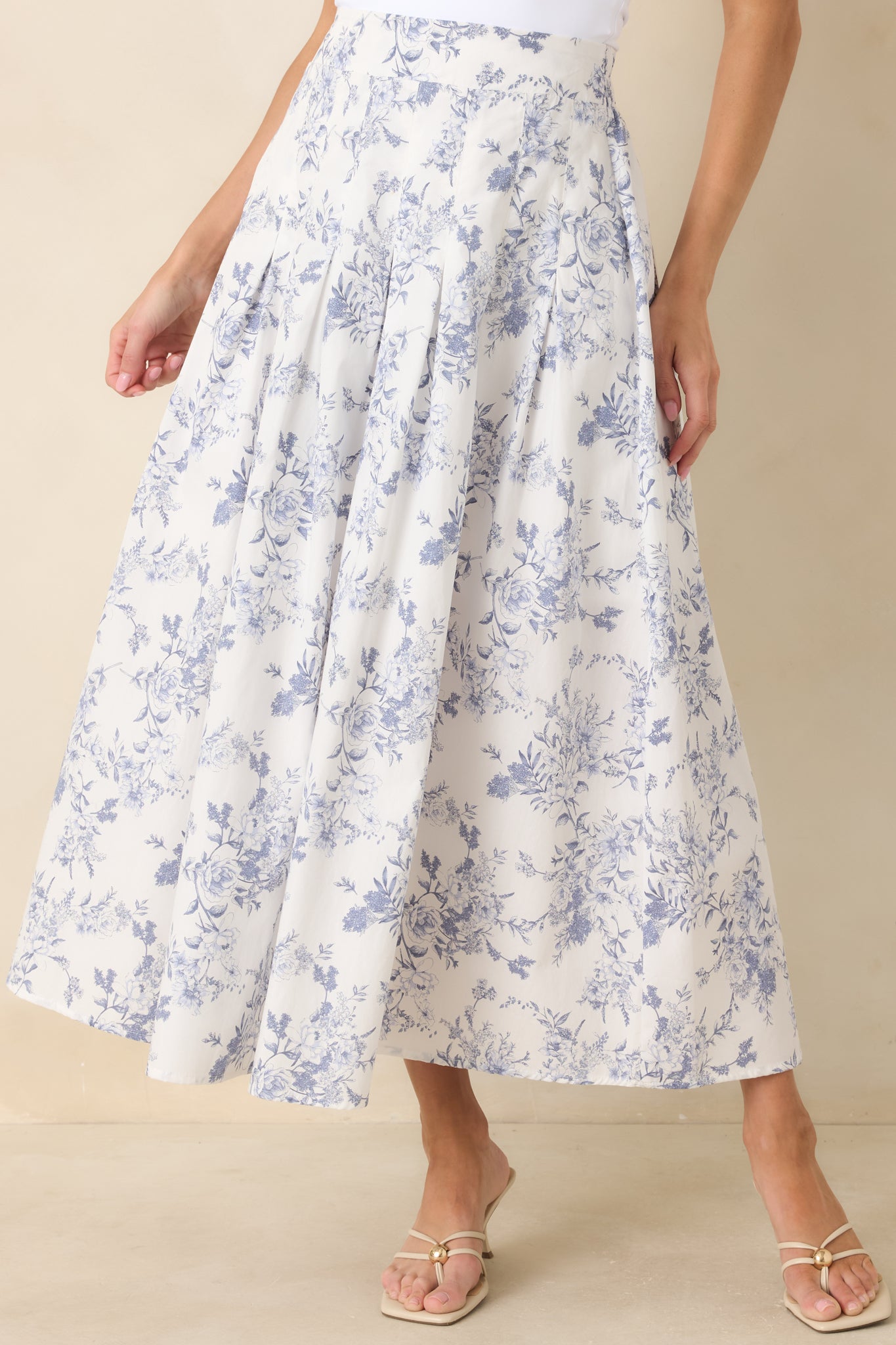 Detail of the skirt’s blue floral print and soft gathered fabric along the waist and upper skirt.